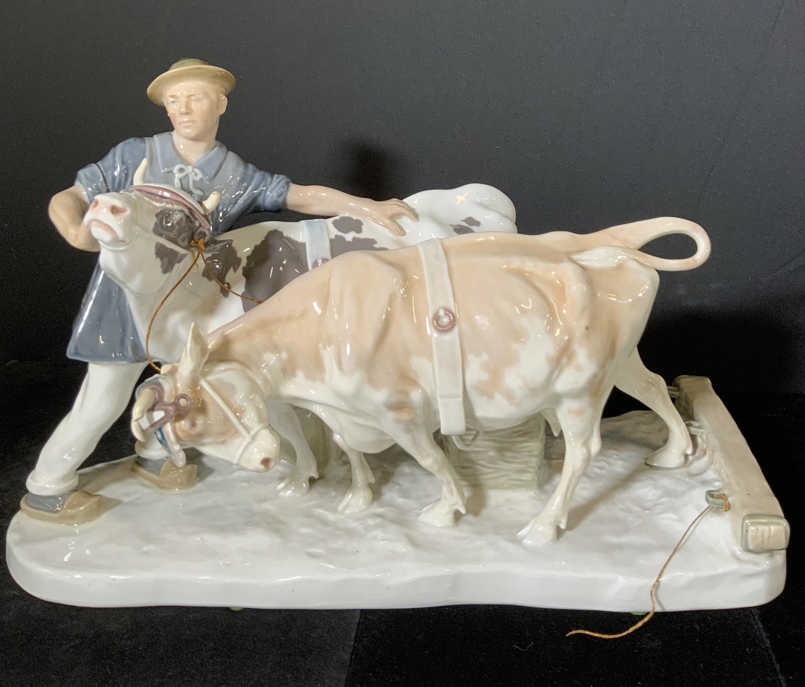 MEISSEN Sig Vntg Porcelain Farmer & Cattle Figural: Large vintage German porcelain figural depicting a farmer and his cattle. The piece features hand painted & glazed white porcelain. One cow is black and white, the other is brown and white. The farmer
