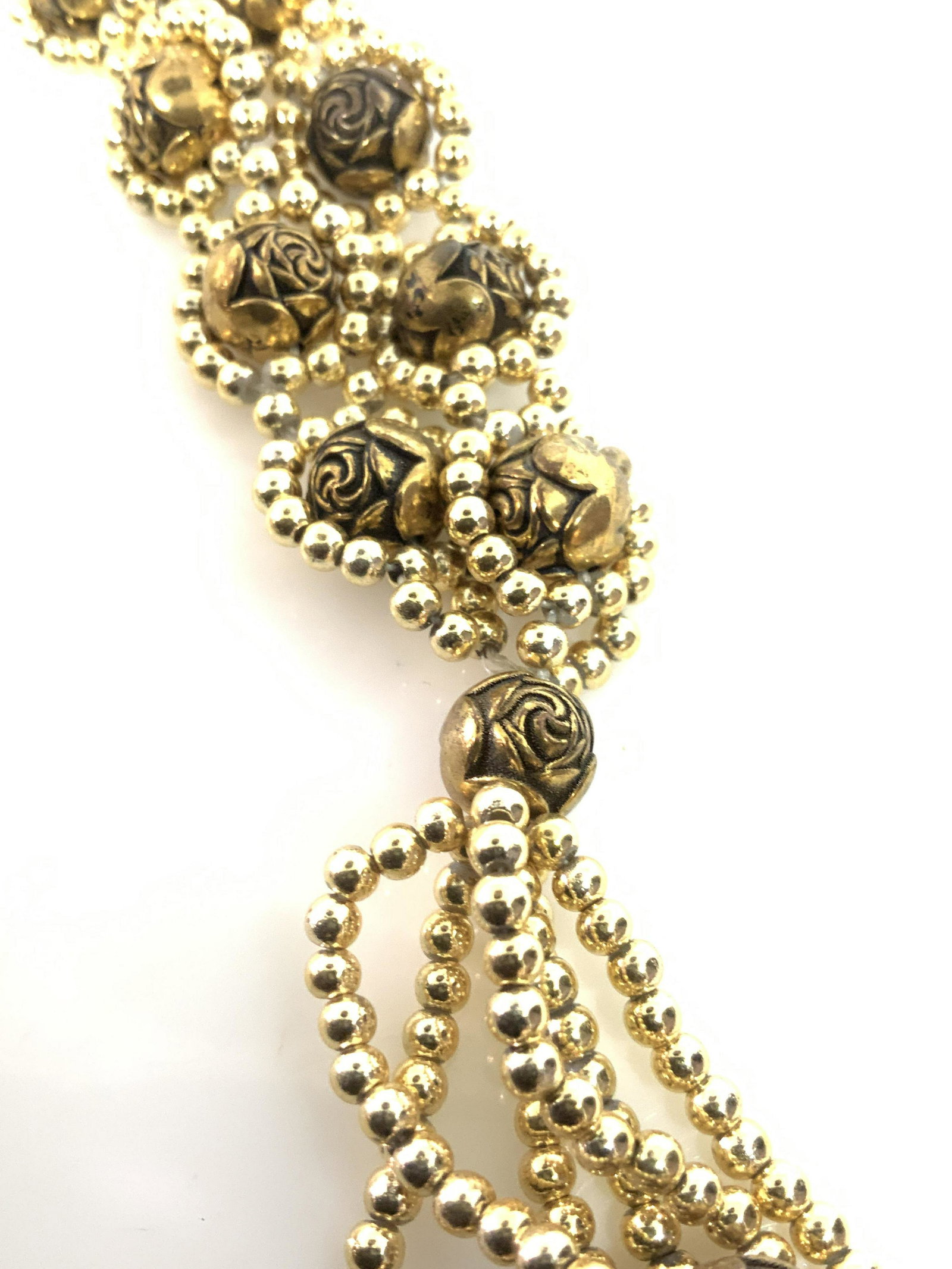 Lot 3 Gold toned Metal Fashion Jewelry: Wear this group together or a separates. Long style beaded necklaces, one with golden etched rose form beads wrapped in a halo of brilliant gold toned seed beads. Necklace forms tassel pendant, 28 in.