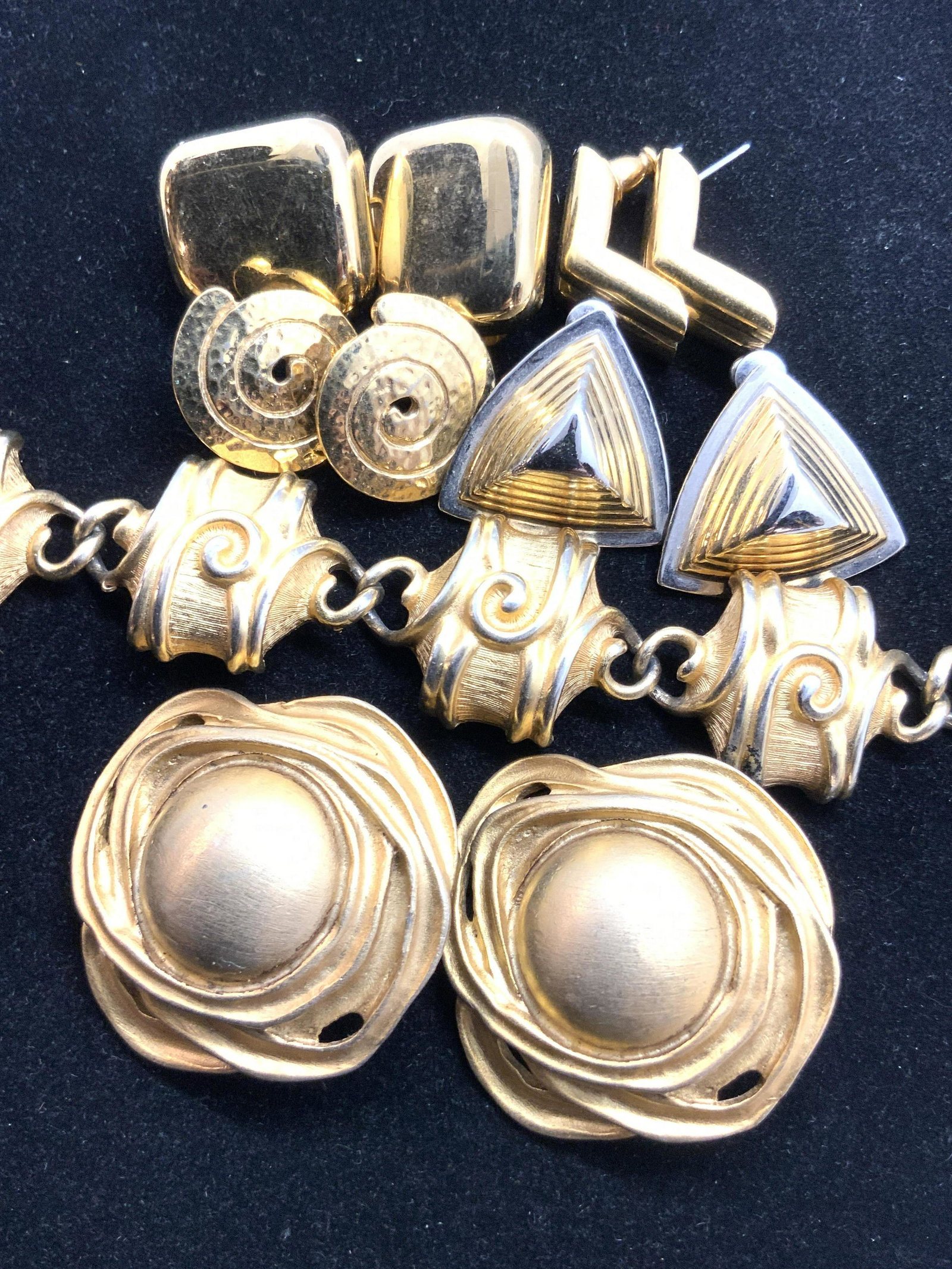 Lot 6 MONET Signed Geometric Earrings & More: Six pieces of jewelry that includes earrings (pierced & clip on) and one bracelet. All pieces are crafted from a gold tone metal and have a geometric shape / design. Bracelet length approx 7 in. Brace