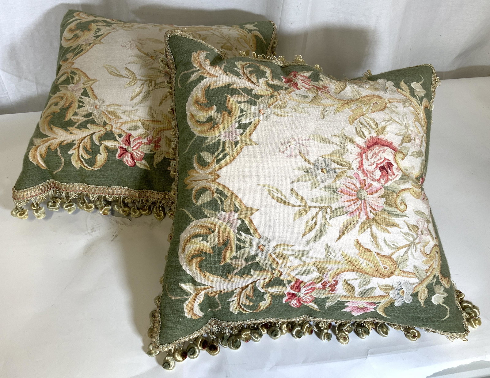 Pair Floral Detailed Aubusson Pillows: Pillows appear to be hand crafted. Each have multi toned floral, leaf & vine detail. Edges have dangling detail, appears to be custom made. Each pillow measures approx 20 inches square. aubusson of ea
