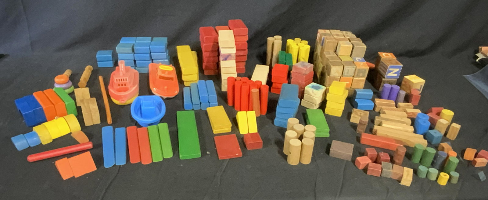 Huge Lot Vintage Children’s Toys: Huge lot children’s toys. Includes hundreds of wooden building block, and several toy boats. Largest piece measures approx 4 inches H, 3 inches W, and 8.5 inches long. Wear is consistent with age an
