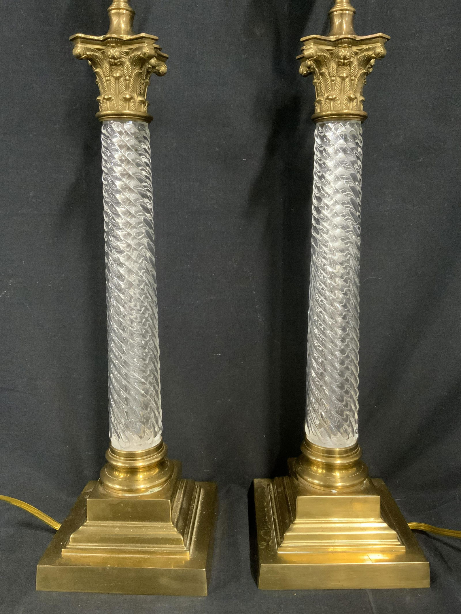 Pair VAUGHAN Twisted Glass Column Lamp: Pair of Vaughan glass column lamps. Glass Column is a molded glass column, a central nickel tube is encased in the columns. The base and capital are solid cast brass. Measures 20.5 inches H, 6.25 inch