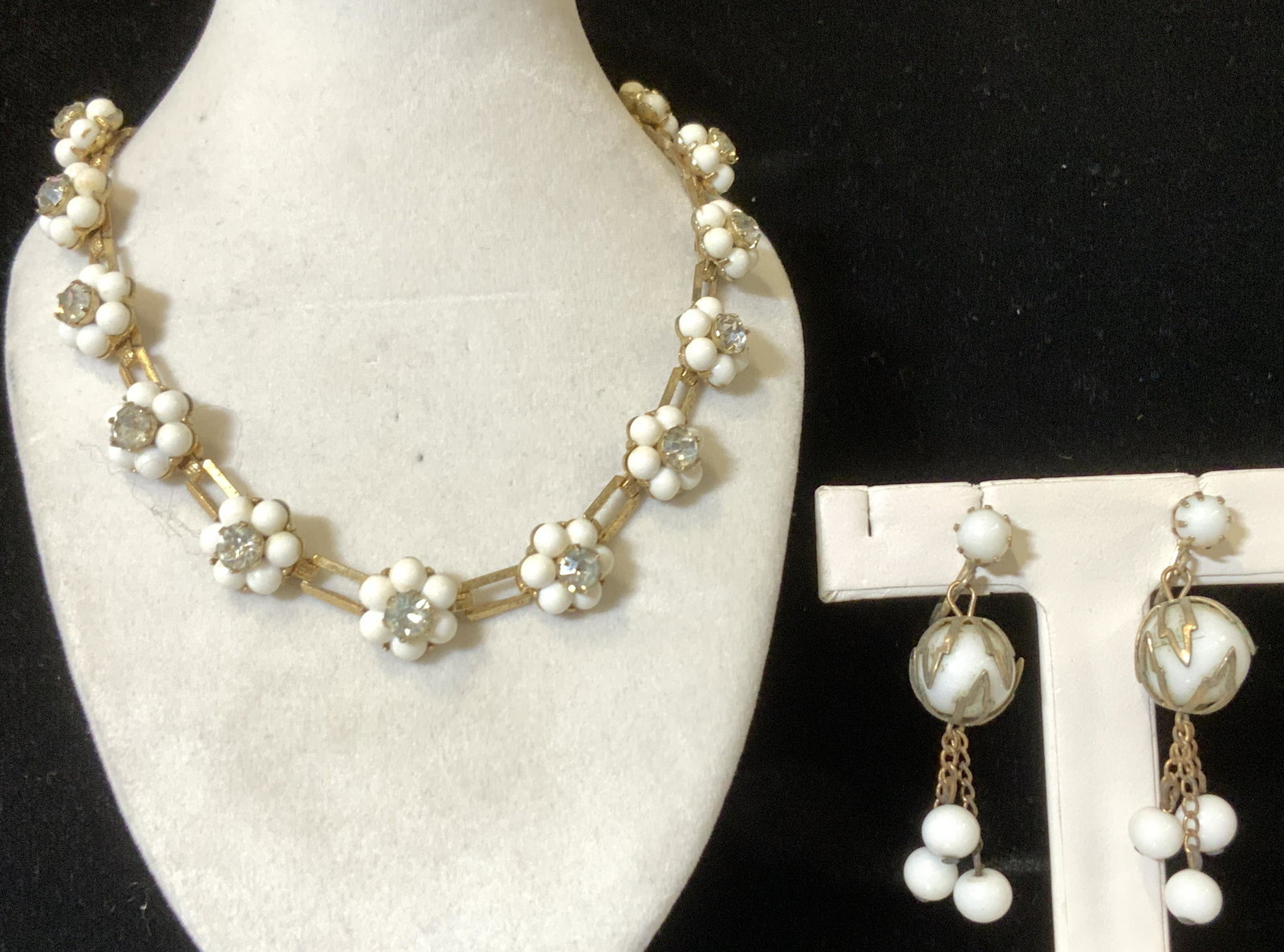 Mid Century Rhinestone White Bead Set Jewelry: c. 1950s Cocktail jewelry, a choker necklace and candle screw back earrings. Necklace chain links are open box form with flower shape reticulated pattern made of center rhinestone with halo of white s