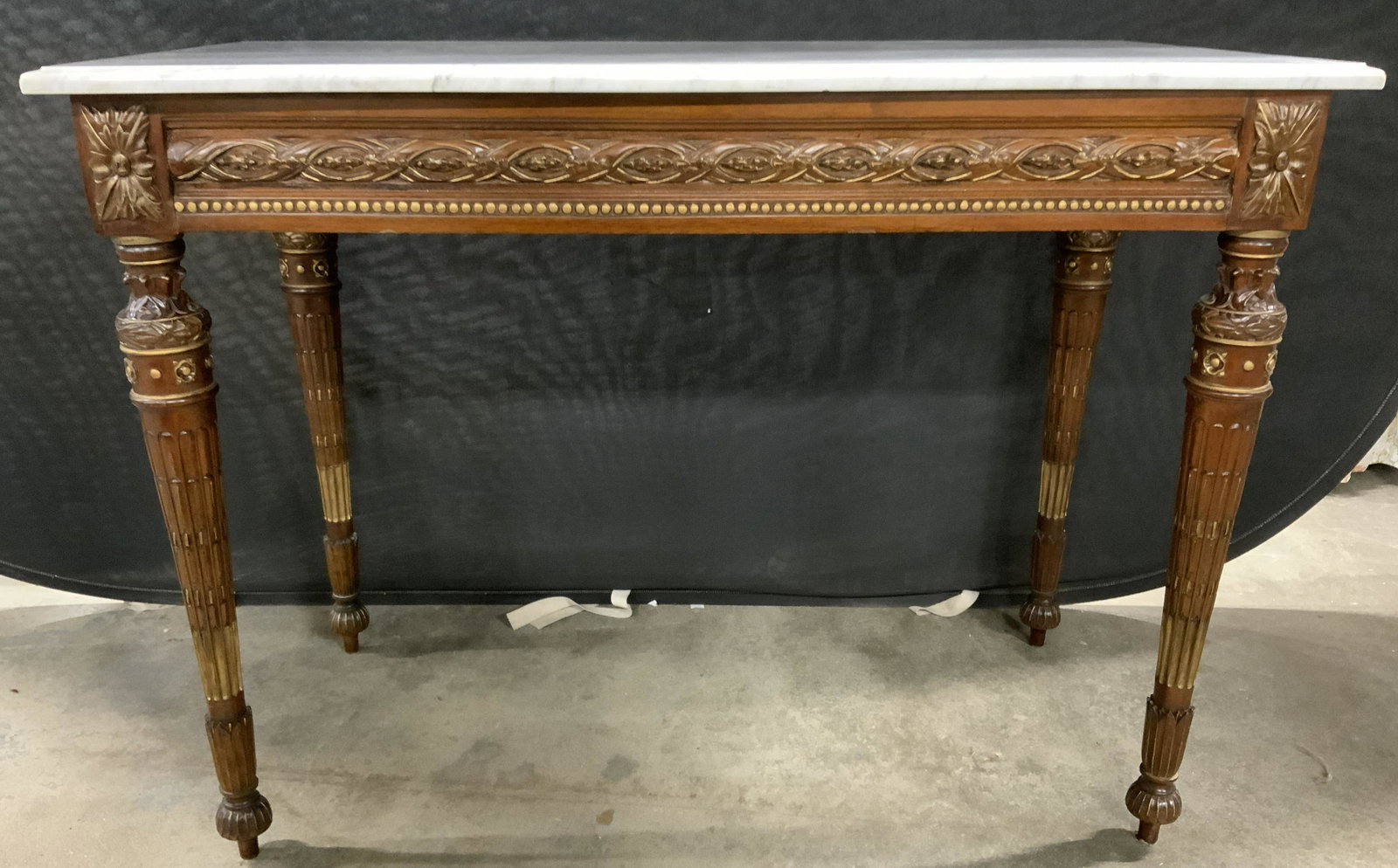 Antique Marble Topped Hand Carved Console Table: Console table is antique. Piece has geometric borders to wide wood apron turned reeded legs, hand applied gold leafing to trim & carved elements, side table, console table, desk, hall table, marble to
