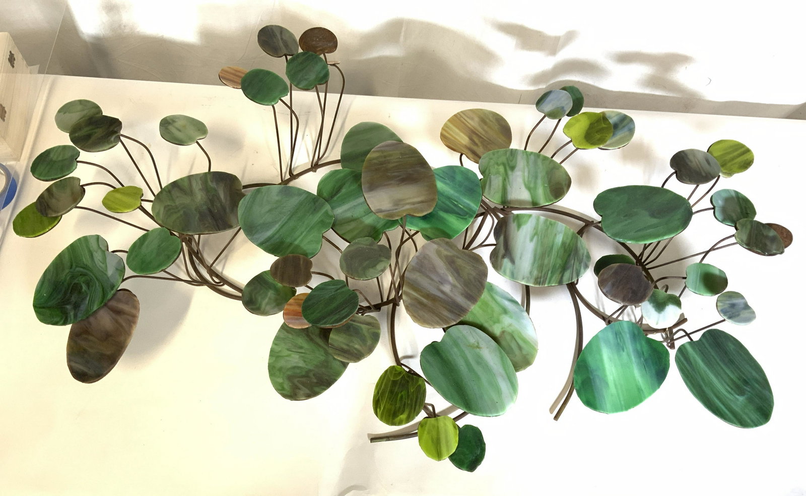 Metal & Glass Leaf & Branch Wall Art Piece: Wall art is metal and glass. Piece has various tones of green & brown glass leaf style structures. Wall art, wall decor, wall sculpture, vine and leaf sculpture, home decor, decorative arts, decorativ