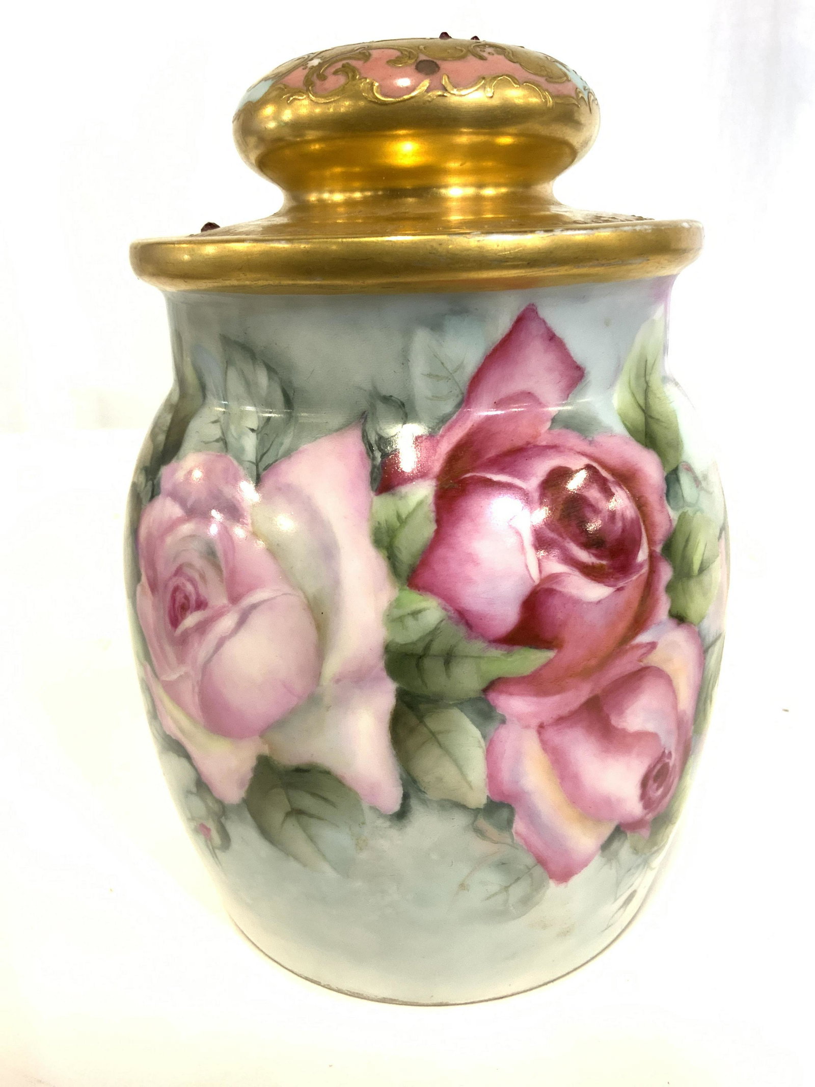 Vintage AKD FRANCE Porcelain Jar W Lid: Underside of jar is marked AKD FRANCE. Jar has intricate multi toned floral & leaf detail. Piece is possibly hand painted. Jar is vintage. Jar lid & rim appear to be gold leafed with red toned rhinest
