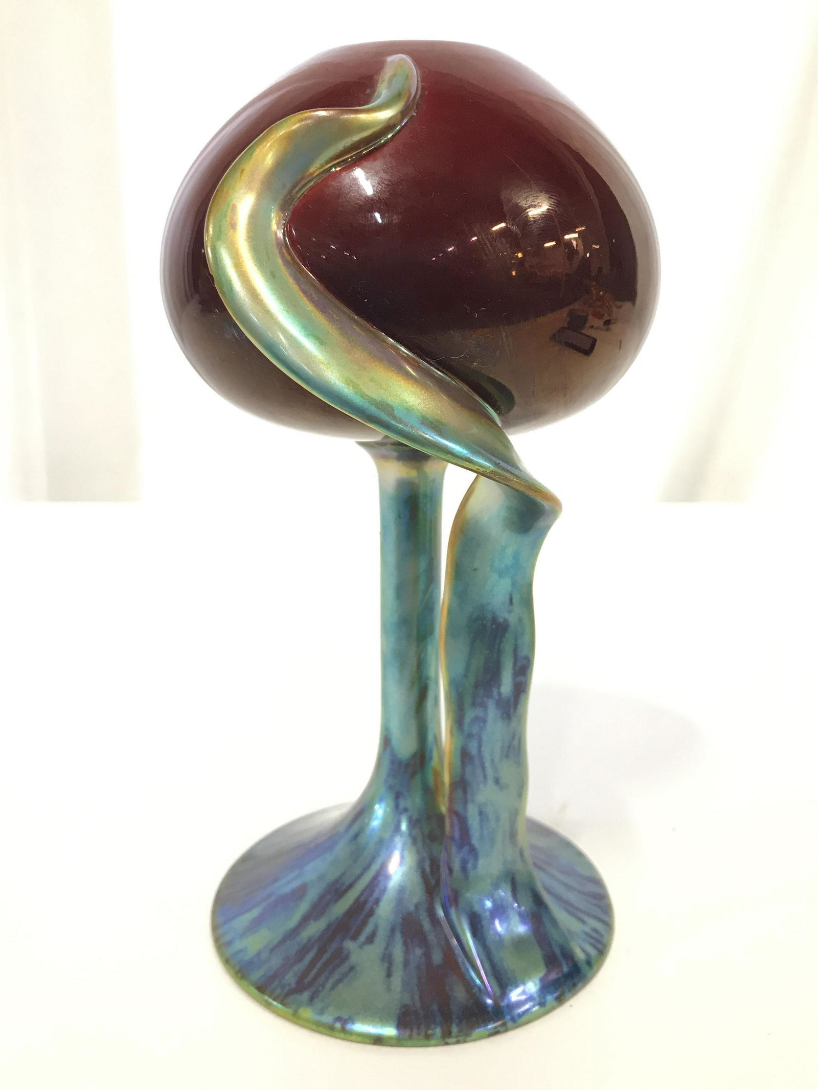 ZSOLNAY HUNGARY Vintage Iridescent Vase: Underside of piece is marked ZSOLNAY HUNGARY HAND PAINTED. Piece is vintage possibly antique. Vase stem is iridescent. Piece appears to be porcelain. Top of vase is cranberry toned. Piece measures app