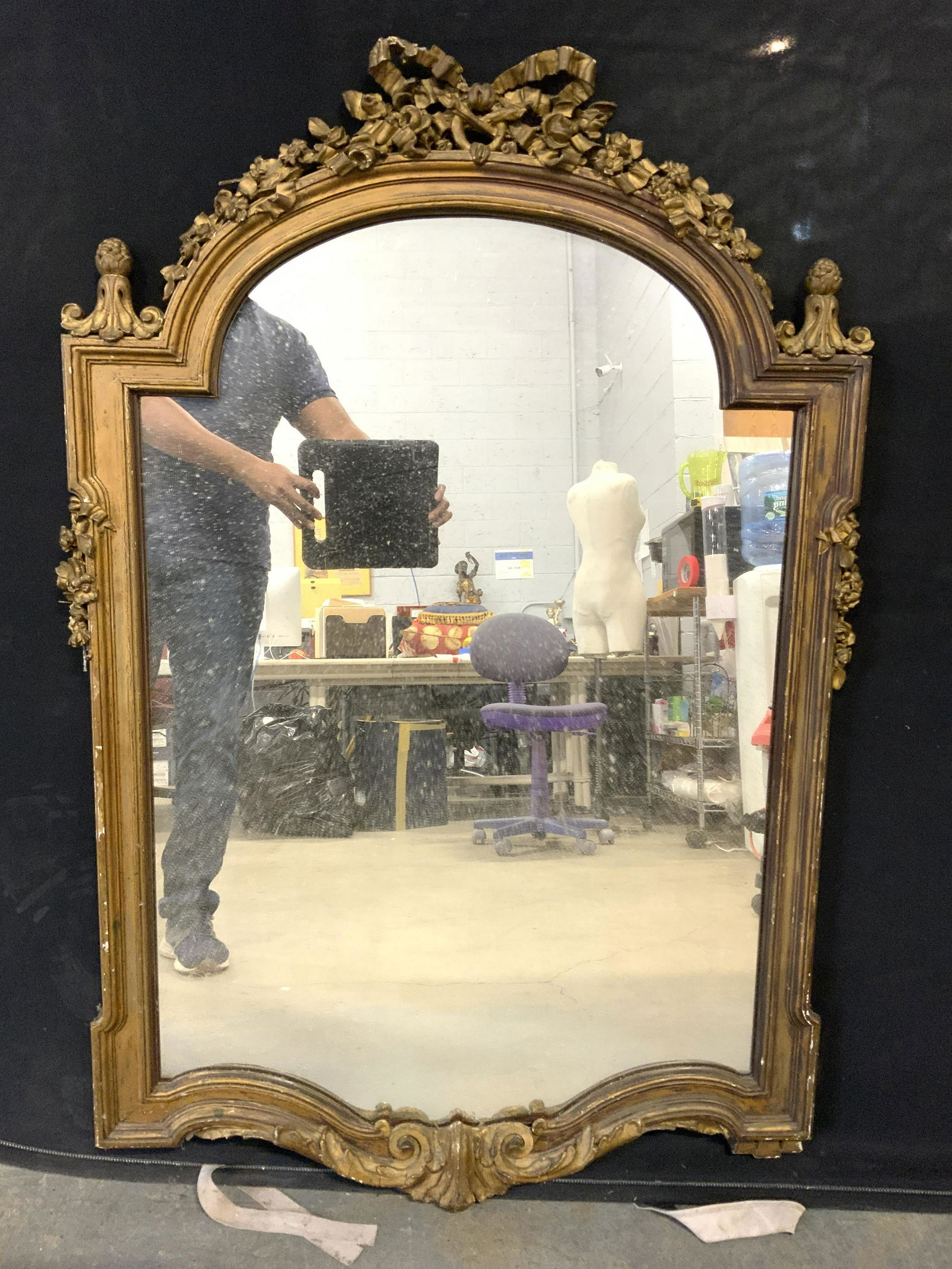 Antique Carved Ornate Gold Leaf Wall Mirror: Wall mirror is vintage possibly antique. Mirror has layer of gold leaf layer. Frame has ornately detailed structures including floral, leaf, c & s scroll structures. Mirror measures approx 48 inches t