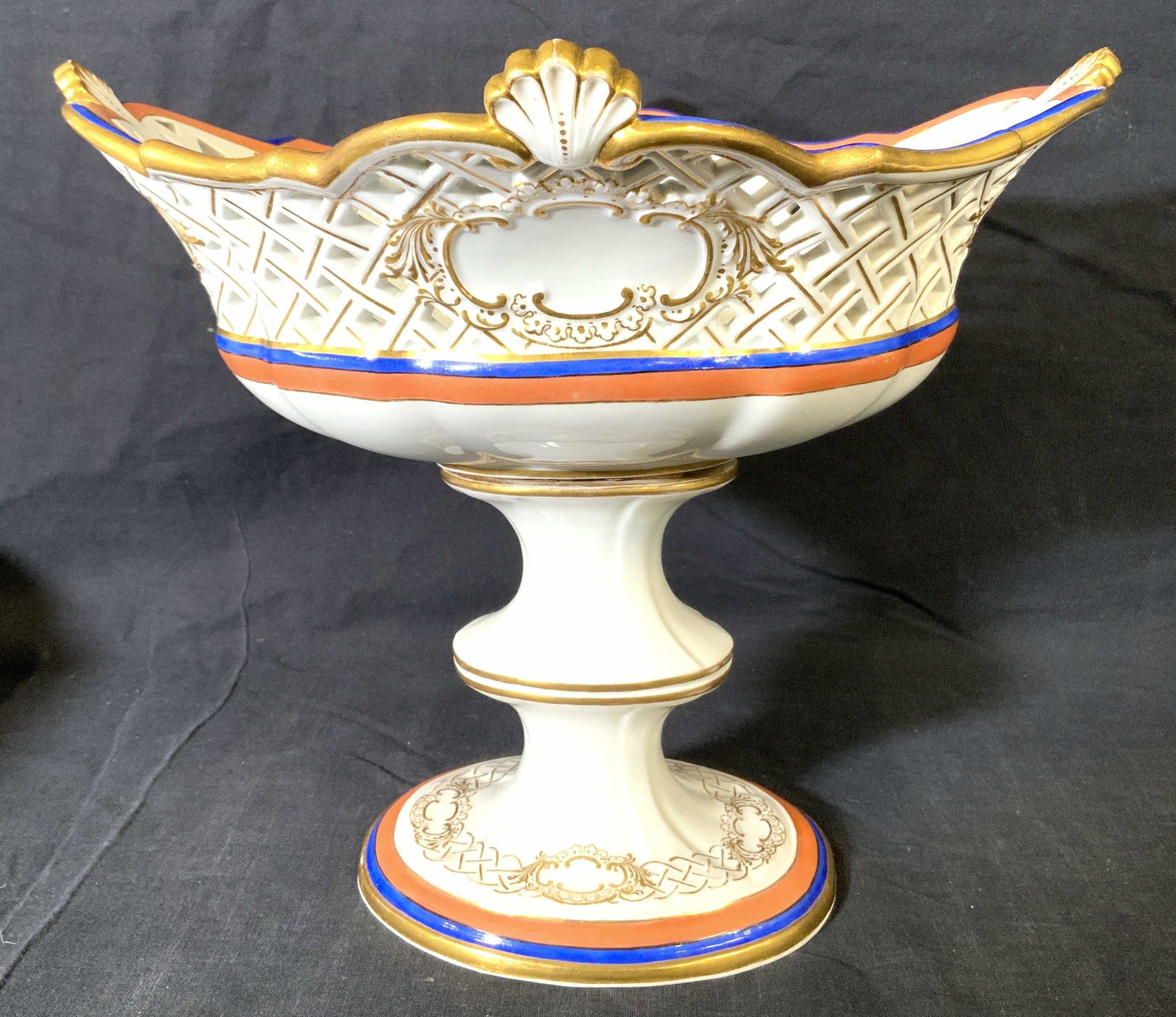 MEISSEN Porcelain Pedestaled Centerpiece Vessel: Underside of piece has MEISSEN trademark. Piece is white with gold toned ornate detail, & blue and orange accent detail around edges. Centerpiece also has pierced detail. Piece measures approx 9.5 inc