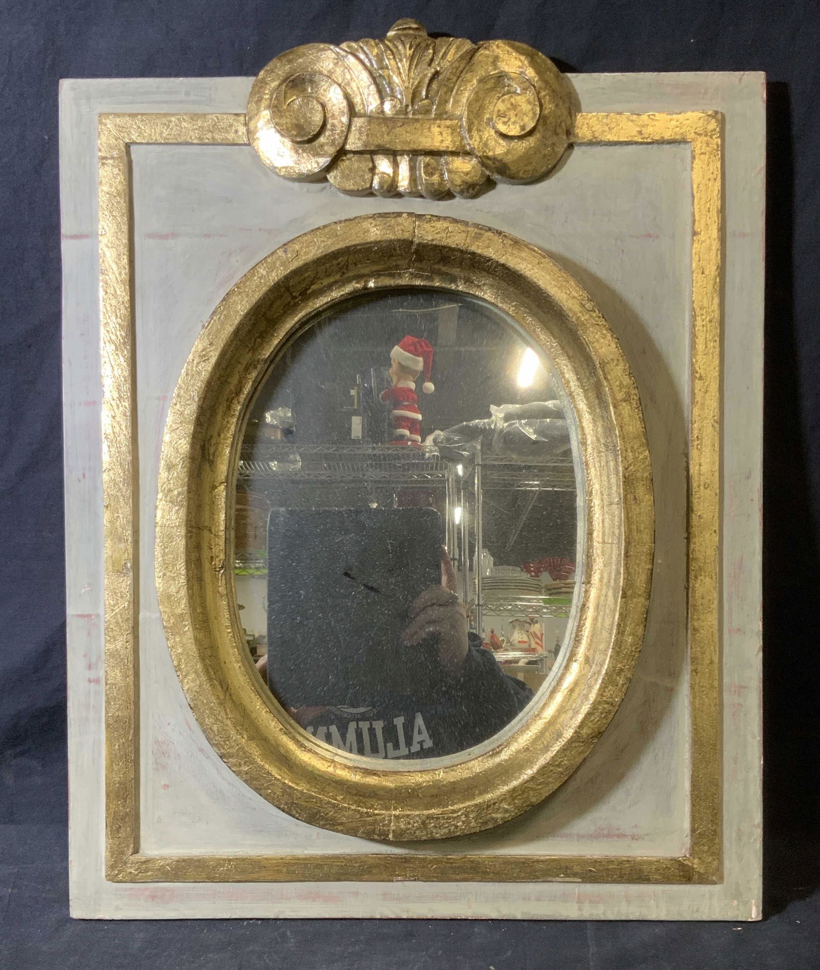 Hand Painted Gold Leaf Mirror: Hand Painted Gold Leaf Mirror, piece consists of an oval mirror mounted on a wooden base, base of mirror painted grey with gold leaf accents throughout, mirror measures 23 inches at tallest and 18.25
