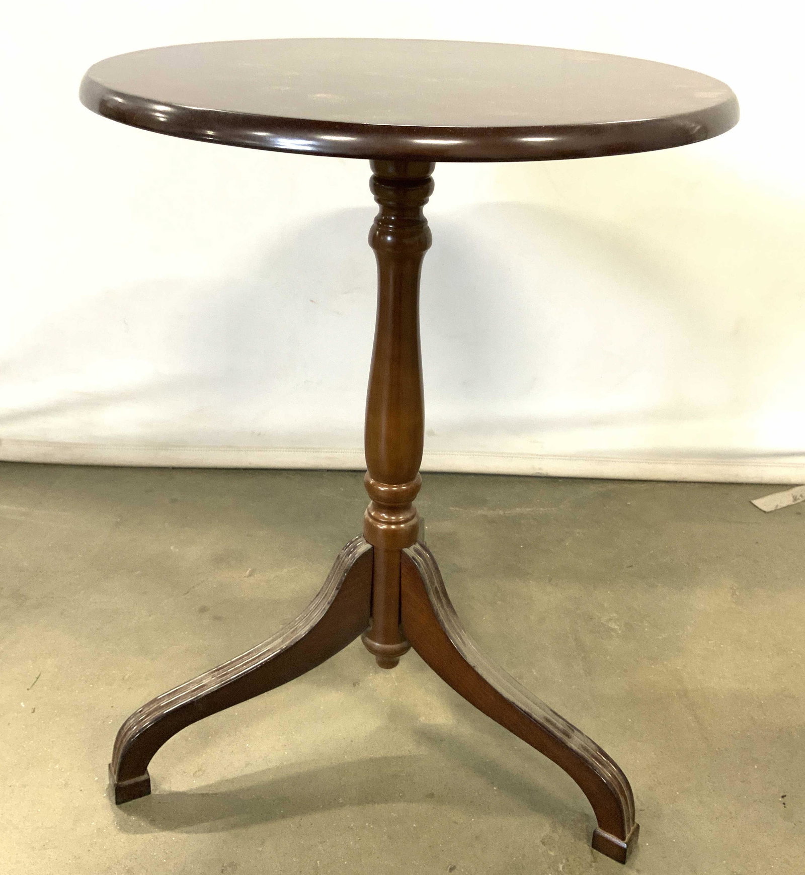 Wooden THE BOMBAY COMPANY Tilt Top Table: Underside of table is marked THE BOMBAY COMPANY. Piece is wooden with oval shaped tilt top. Piece has tripod style carved wooden feet. 20.5 inches tall 19 inches long 15 inches wide. Tilt top table, w
