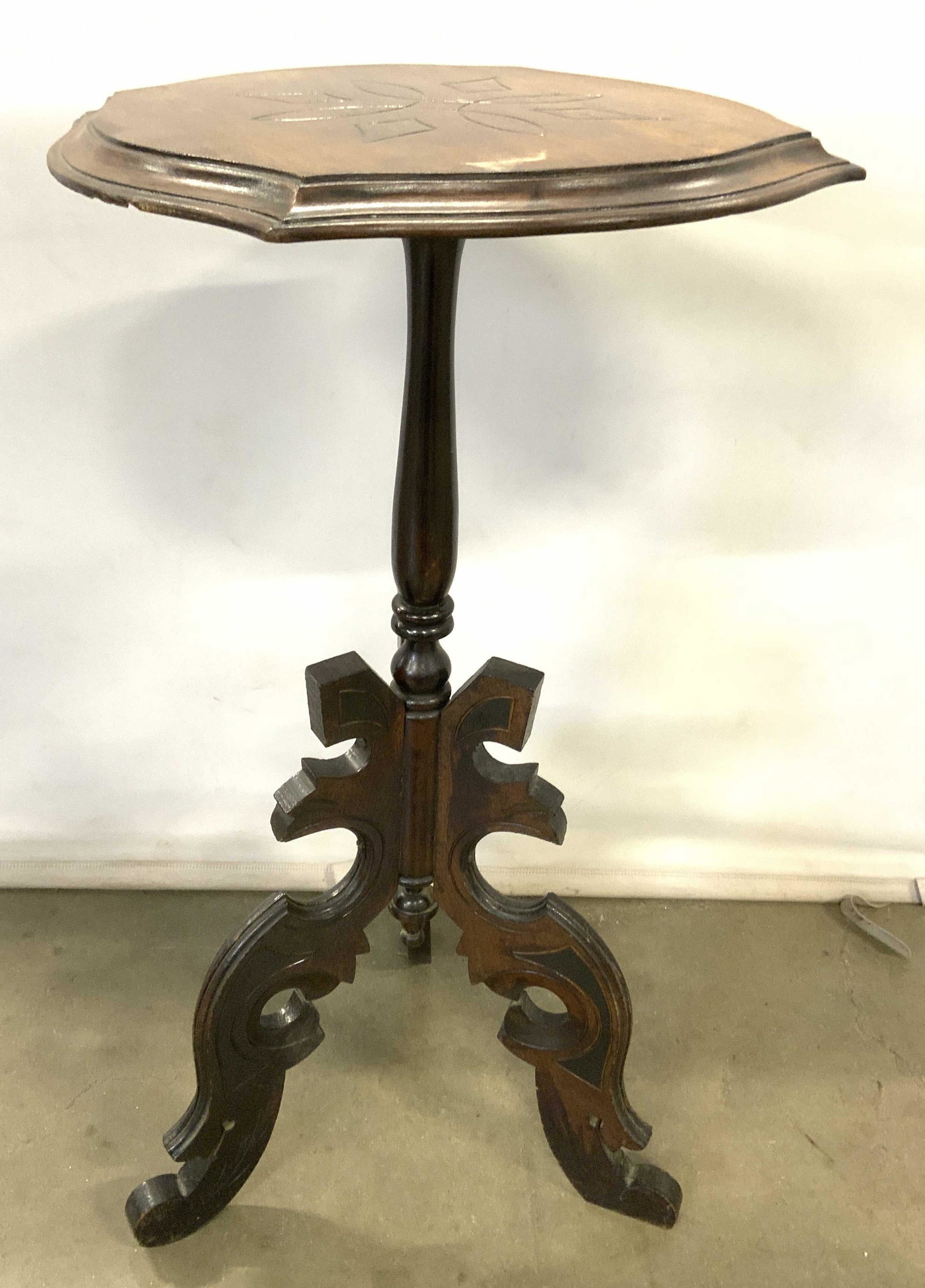 Vintage Intricately Carved Wooden Pedestal Stand: Pedestal is vintage possibly antique. Piece has intricately carved tripod style legs half way down structure. Tabletop has geometric carved wooden relief detail. Some areas may be hand crafted. Piece 