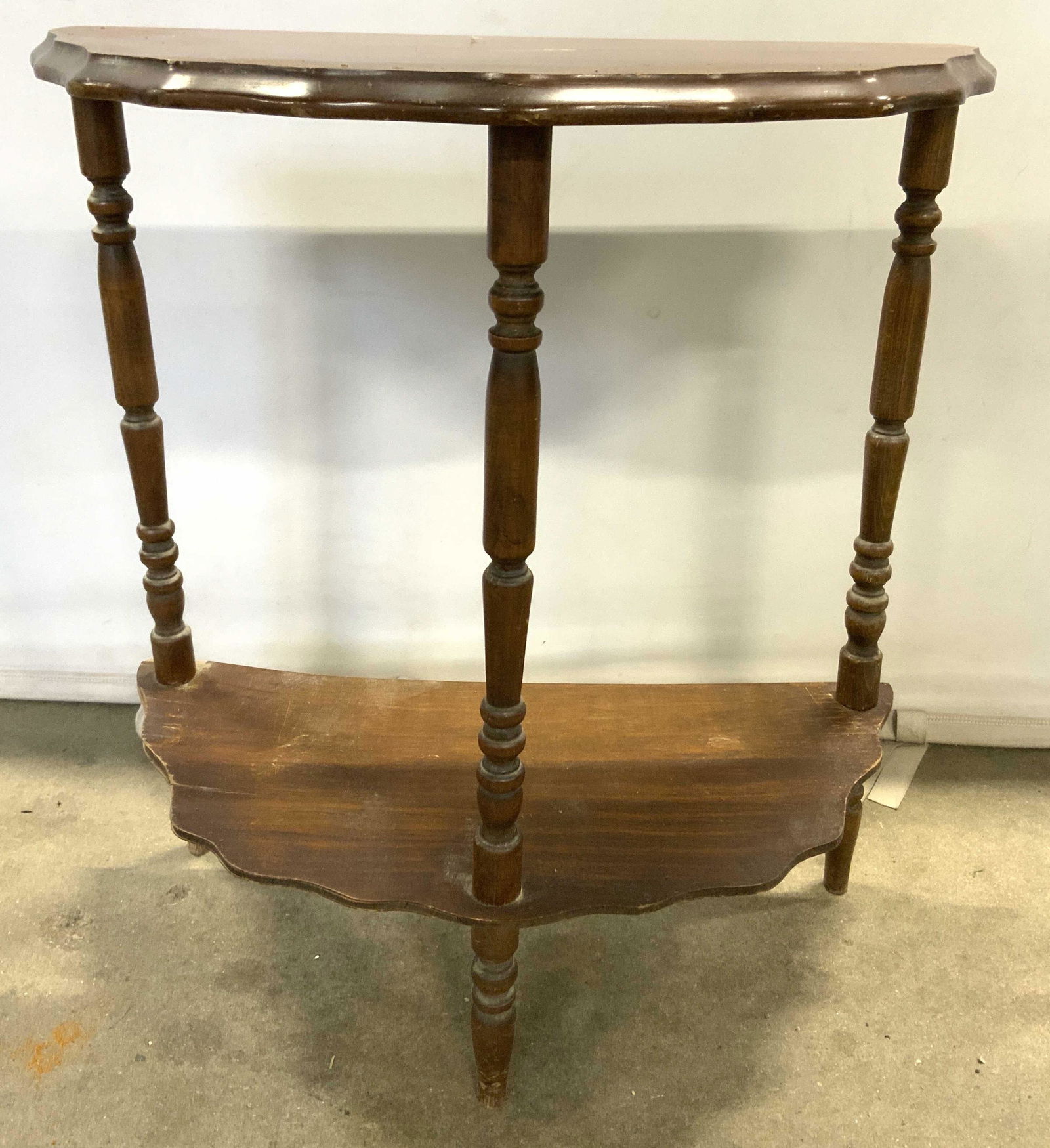 Vintage Petite Carved Wooden Demilune Table: Demilune table is vintage possibly antique. Piece is possibly hand crafted. Table has 3 carved wooden legs with stretcher in between. Piece measures approx 24 inches tall 22 inches wide 11 inches deep