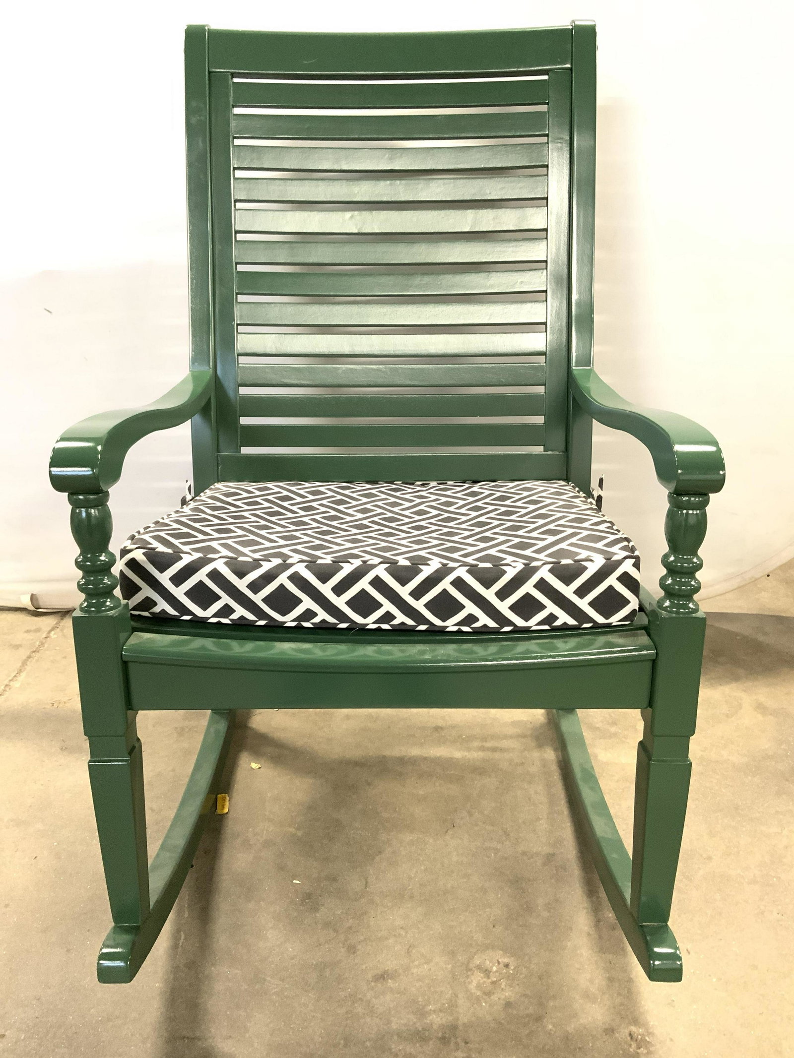 GRANDIN ROAD Nantucket Rocking Chair: Cushion label reads GRANDIN ROAD. Chair is green toned. Piece has flat ladder style backrest. Piece includes white & slate toned cushion with geometric detail. Chair measures approx 42 inches tall 25 