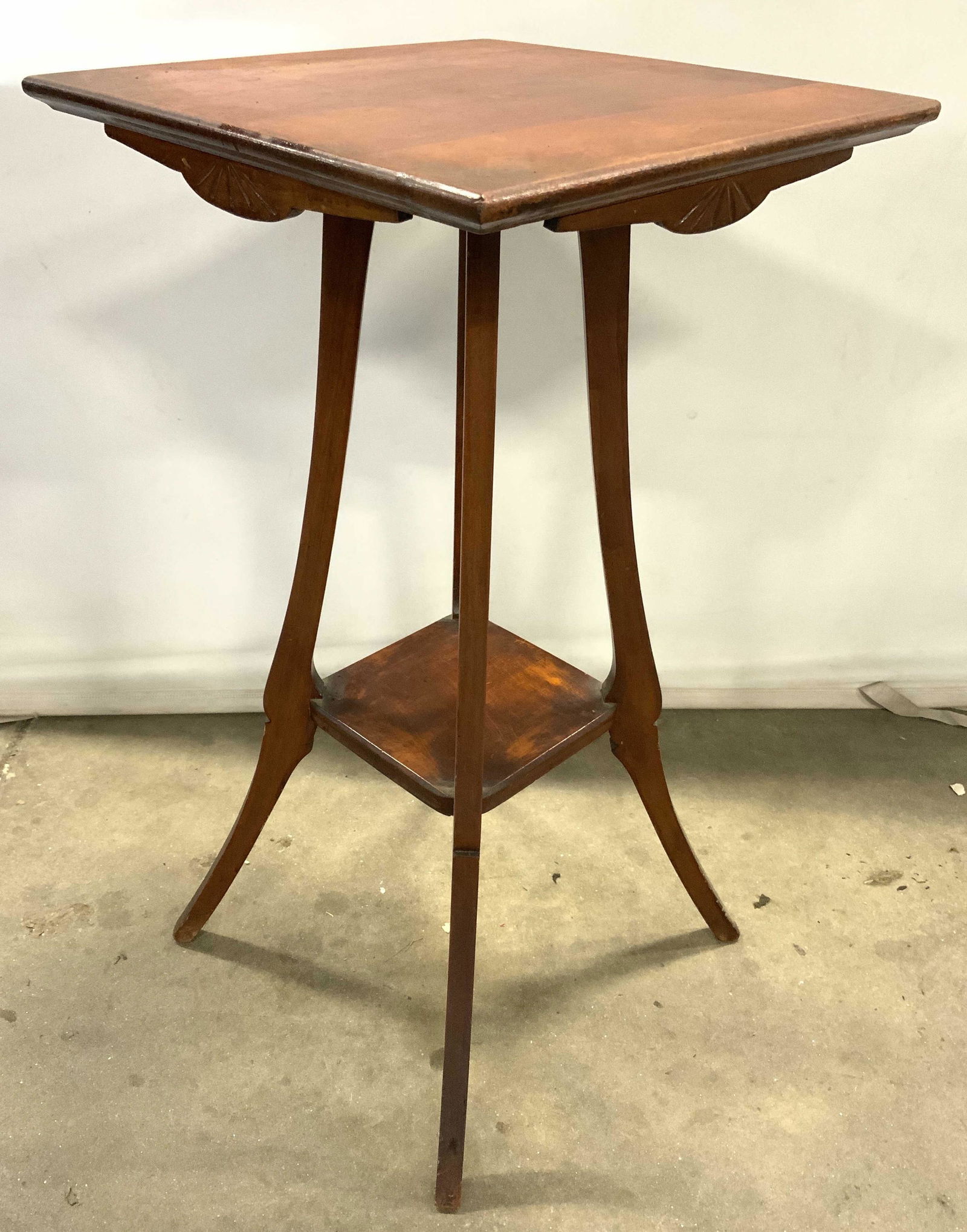 Antique 2 Tier Parlor Lamp Table Side Table: Lamp table is vintage possibly antique. Piece appears to possibly be oak. Table has carved wooden relief detail directly under top. Table has slightly curved splayed legs with board stretcher in betwe