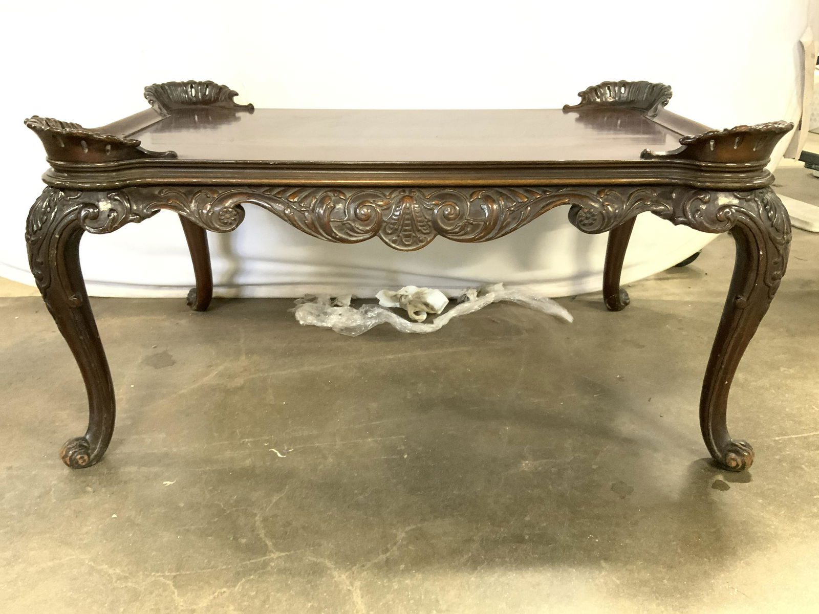 Vntg Scalloped Carved Wooden Coffee Table: Coffee table is vintage possibly antique. Piece has scalloped and intricately carved wooden detail. Table is possibly hand crafted. Corners have raised carved wooden edges. Piece measures approx 34 in