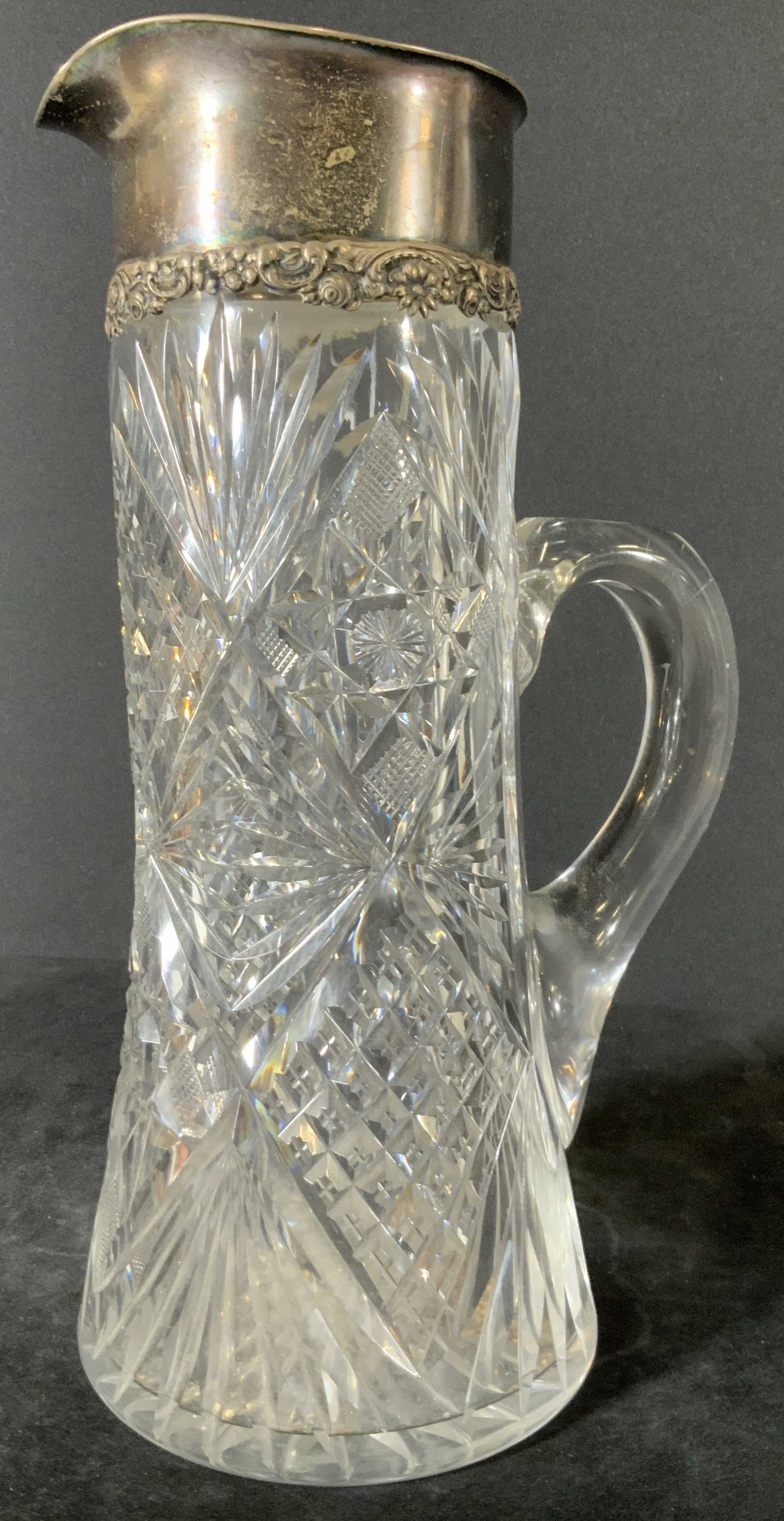 Vintage STERLING SILVER Cut Crystal Pitcher: A vintage sterling silver topped cut crystal pitcher. The piece has a sterling topper with embossed floral accents along the rim. The piece is engraved, illegible. Along the rim reads: STERLING 925 FI