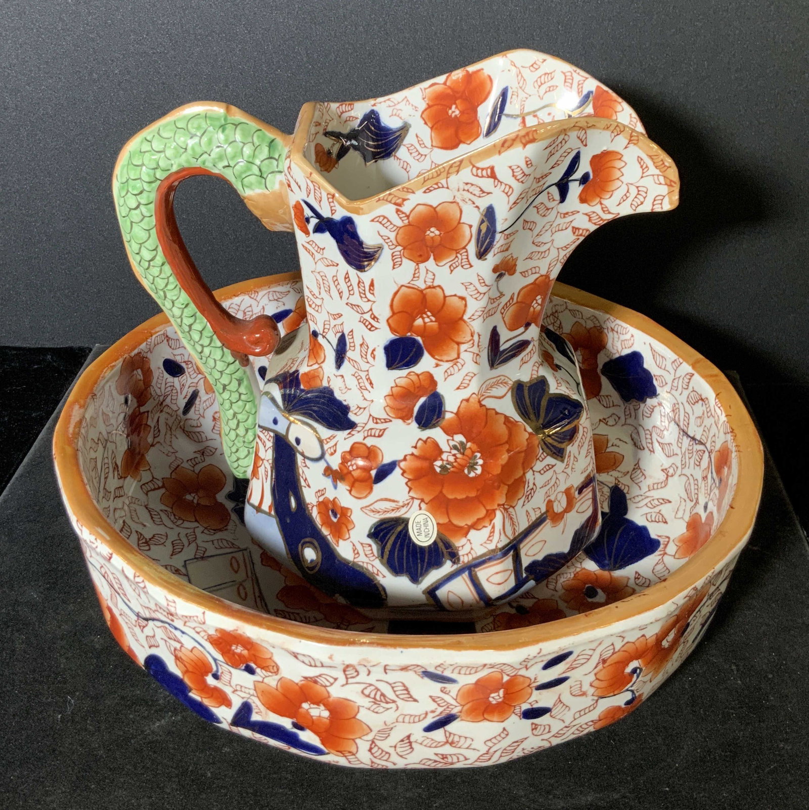 Set 2 Signed IRONSTONE CHINA Imari Style Tableware: An Imari style ironstone China set featuring a bowl / wash basin and a pitcher. Both possibly vintage. Pieces feature white ironstone China accented with cobalt, saffron, and green hues. The piece is 