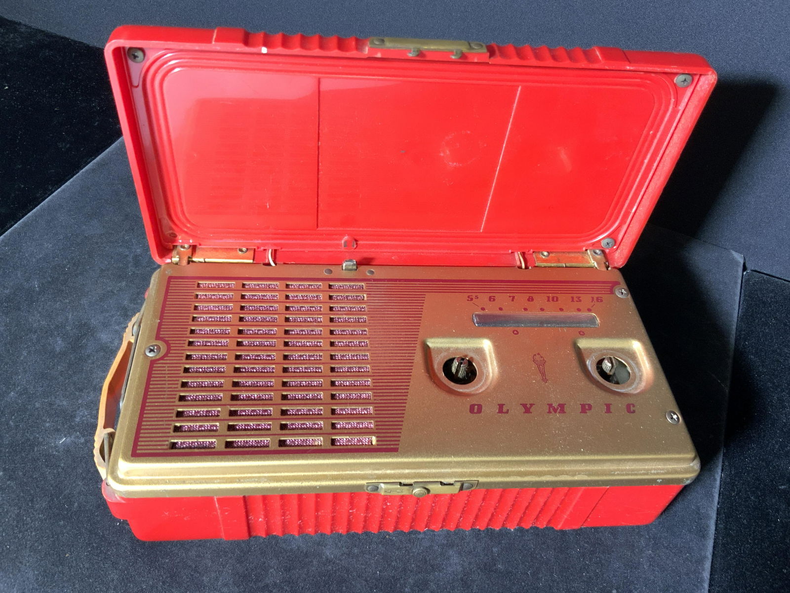 Vintage Handheld Red OLYMPIC Model 449 Radio: Circa 1954 Olympic radio. Piece created by Olympic Radio & Television Co. Red composite material exterior, interior composite metallic gold tone material. Interior original sticker reads Model 449. Pi