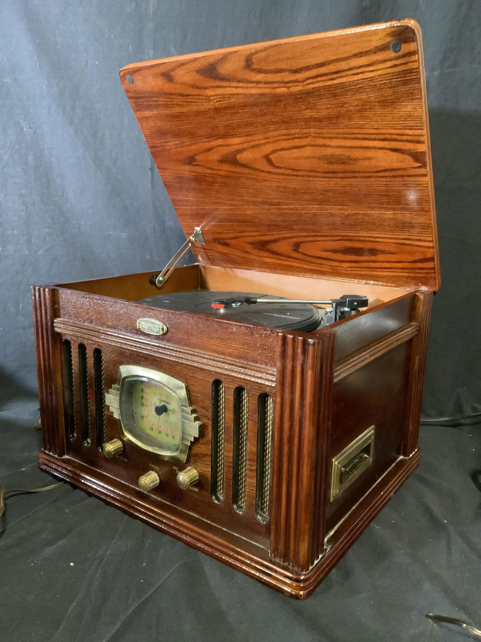 CROSLEY CR67 Turntable & Radio w Cassette Deck: Crosley turntable radio. Crafted from wood, glossy finish. Hosts a multi speed record player, a radio, and a cassette deck. Measures approx 17.5w X 11d X 14.25h. Wear is consistent with age and use. F