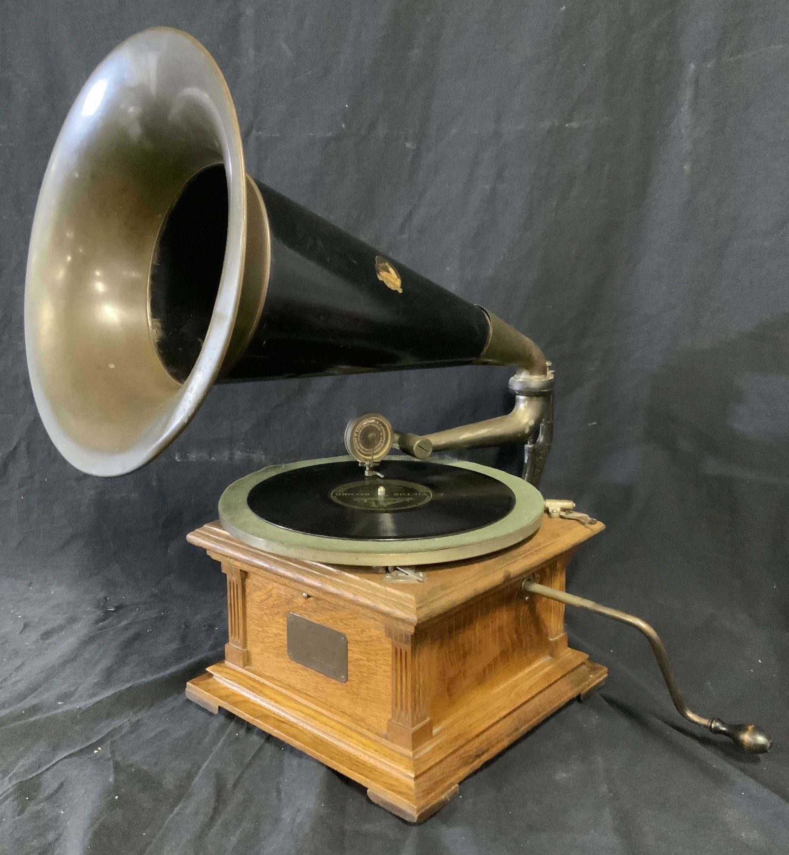 Antique VICTOR TALKING MCH CO Phonograph: Antique phonograph. Crafted by VICTOR TALKING MCH CO. A VICTOR TALKING MACHINE logo is printed on the phonographs horn, a brass plaque on the front of the machine reads as VICTOR, MADE BY VICTOR TALKI