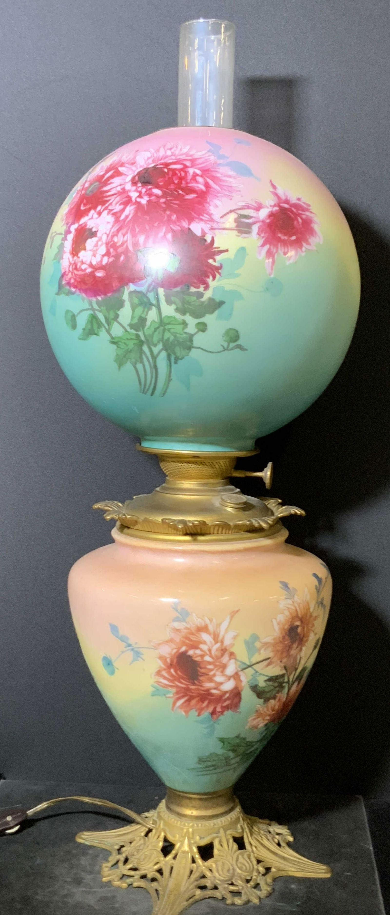 Floral Gone With The Wind Style Art Glass Lamp: A thick walled art glass lamp. A Victorian / Gone With The Wind style lamp. The top glide is removable. It is hand painted with pink hued chrysanthemum flowers. Pink, yellow, and green hues accent the
