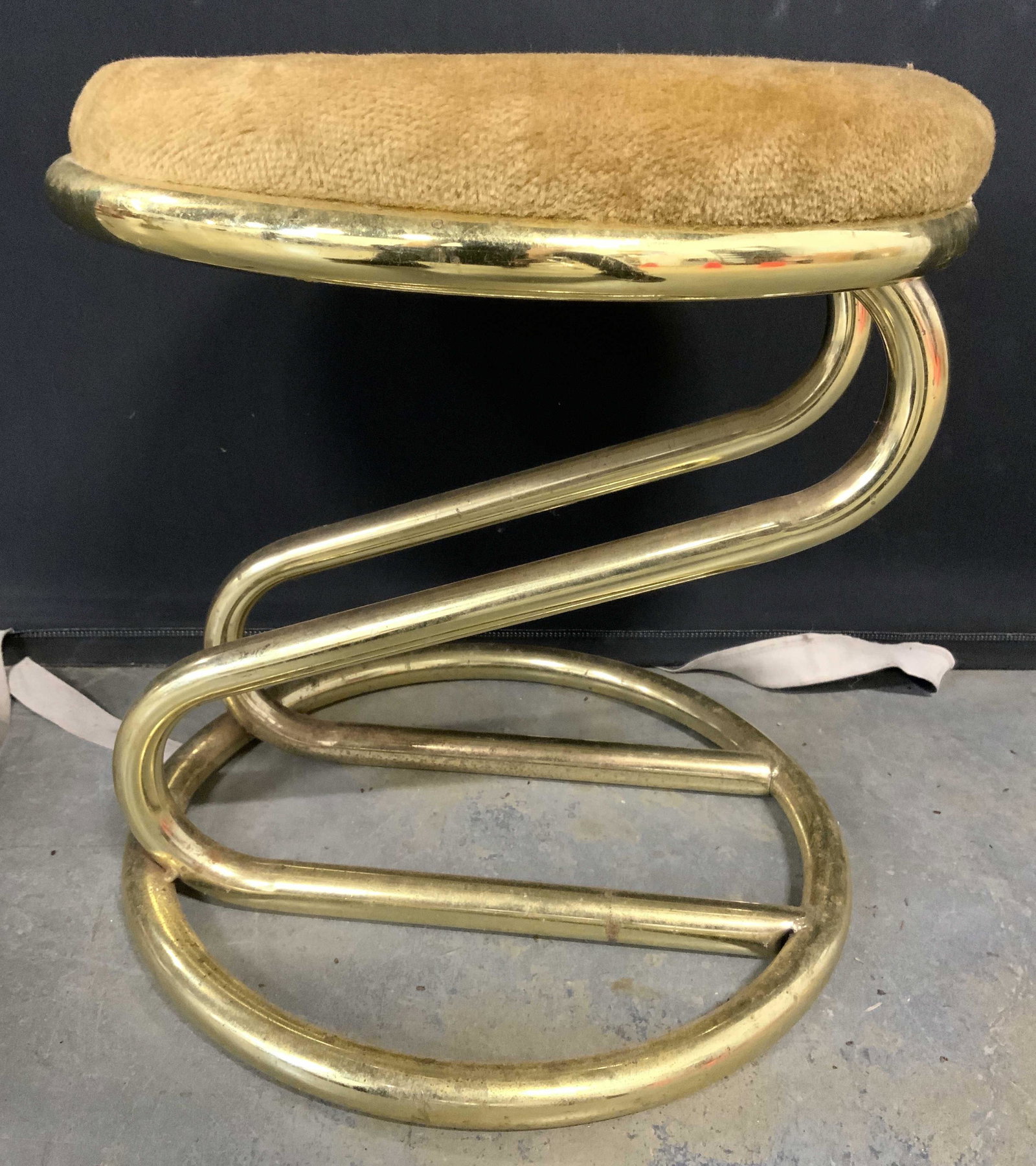 Retro Round Metal Frame Stool W Cushioned Seat: Stool has gold toned Metal base. Seat is beige toned & cushioned. Piece has round seat & lower end of base piece measures approx 16.5 inches tall 15 inches wide. Stool, low stool, metal stool, mcm sty