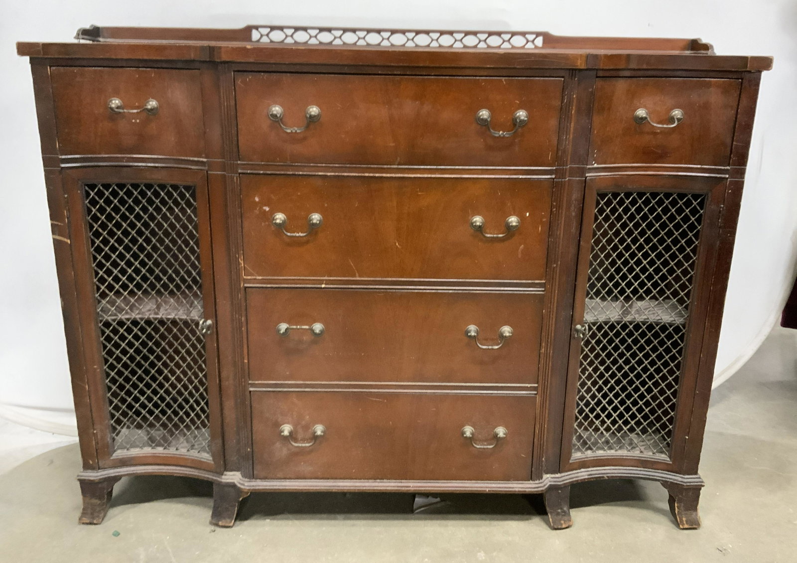 Vintage Wooden UNION NATIONAL Console Table: Vintage wooden console table. 6 drawers, each with metal drawer pulls, two doors. Doors are windowed, windows are metal lattice. Decorative trim atop table is pierced. Drawer joints are dovetailed. Fa