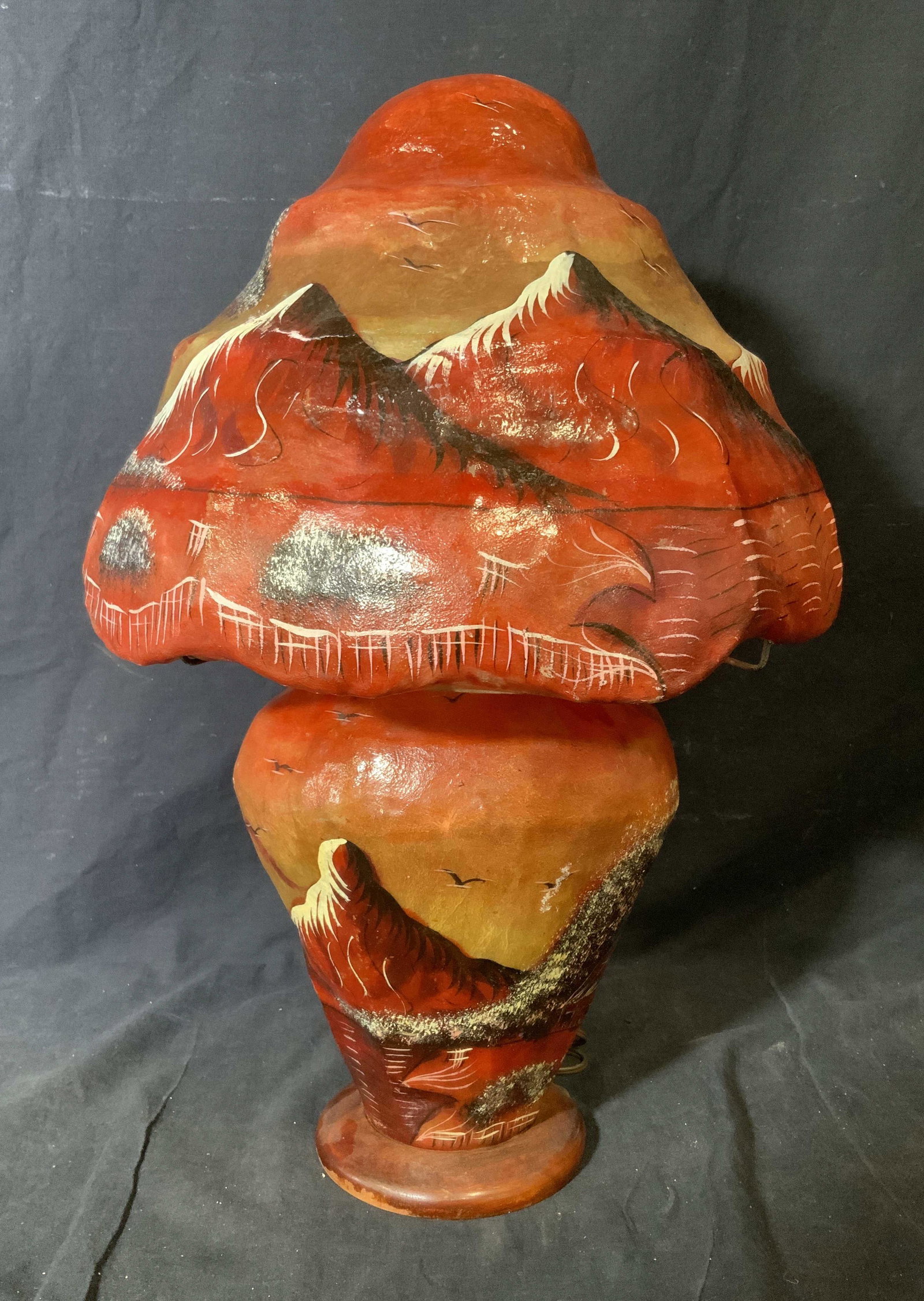 Hand Painted Pakistani Paper Mache Lamp: Hand painted Pakistani paper mache lamp, lamp painted in earthy clay colors, design to lamp depicts a landscape of sorts with mountain portrayed on the lamp shade, both body of lamp and shade are made