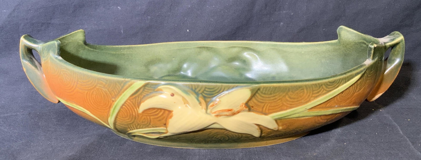 Roseville Pottery Ceramic Centerpiece Bowl: Roseville pottery ceramic centerpiece bowl, underside of bowl reads ‘Roseville USA 479-14’, exterior of piece decorated with lillies in orange green and creme, interior colored in green, rim measu