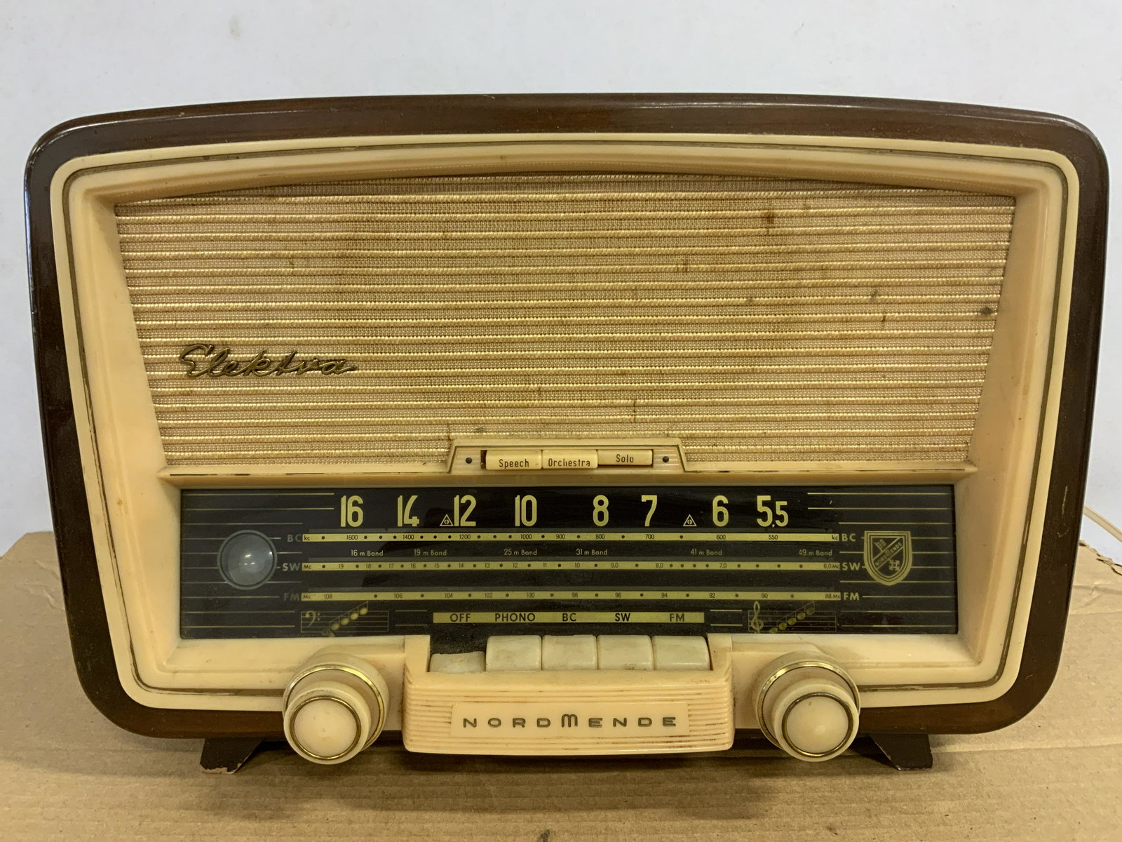 Vintage STERLING ELEKTRA 57 USA Radio: Vintage STERLING ELEKTRA 57 USA Radio. Casing is wood. Face is plastic, possibly Bakelite. Off button seems to be stuck. Measures approx 10 inches H, and 15.5 inches W. Piece is not tested for working