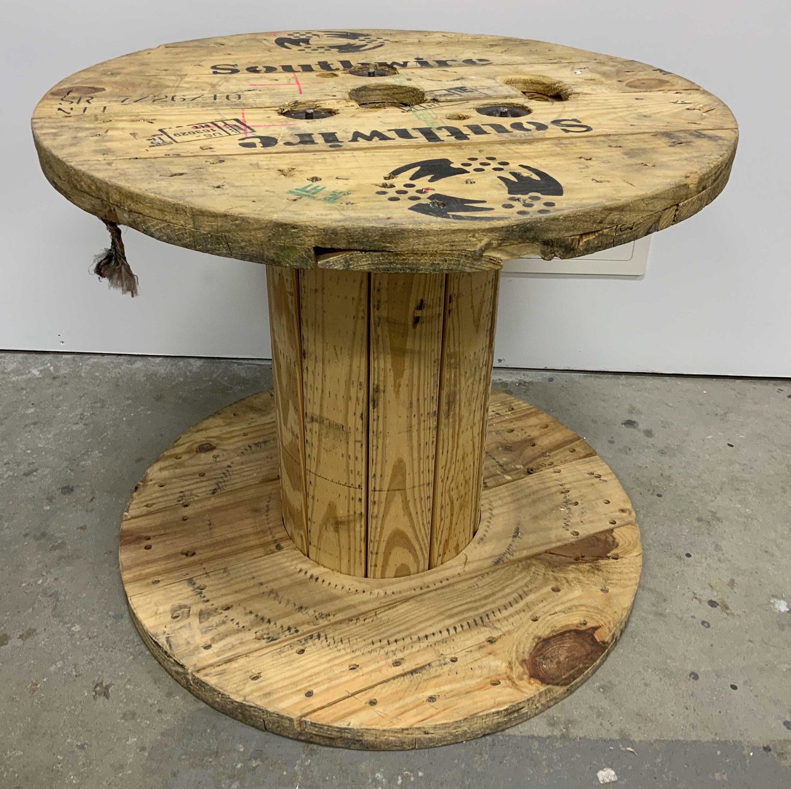 Vintage Wooden Spool Table: Wooden cable reel/spool table, possibly vintage. Reads as SOUTHWIRE. Originally served as a display table in LORD & TAYLOR’s flagship Manhattan store. Measures approx 27.5 inches in diameter, and 24