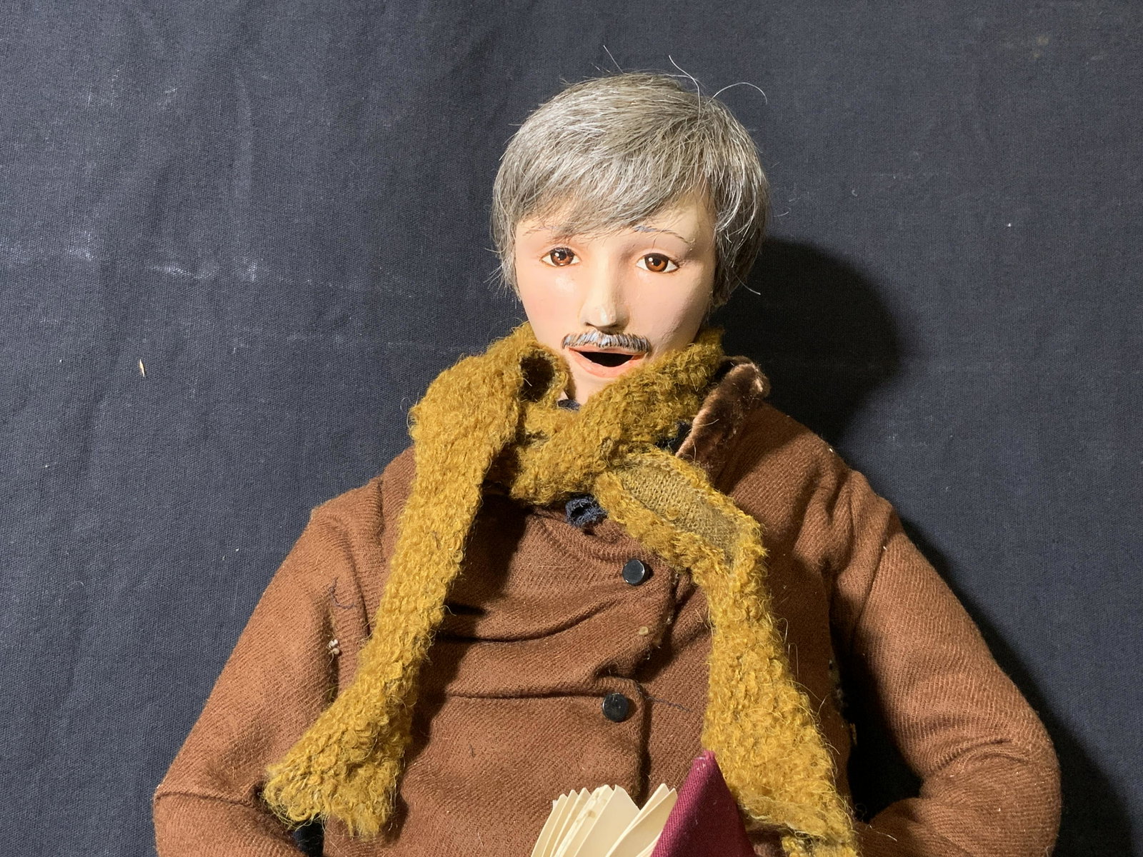 LORD & TAYLOR Window Display Holiday Animatronic: LORD & TAYLOR Window Display Animatronic, no apparent inscriptions or marks, a man in singing with a book, arms have mobility, head and neck needs repair, chips and rips to piece, measures 21 inches a