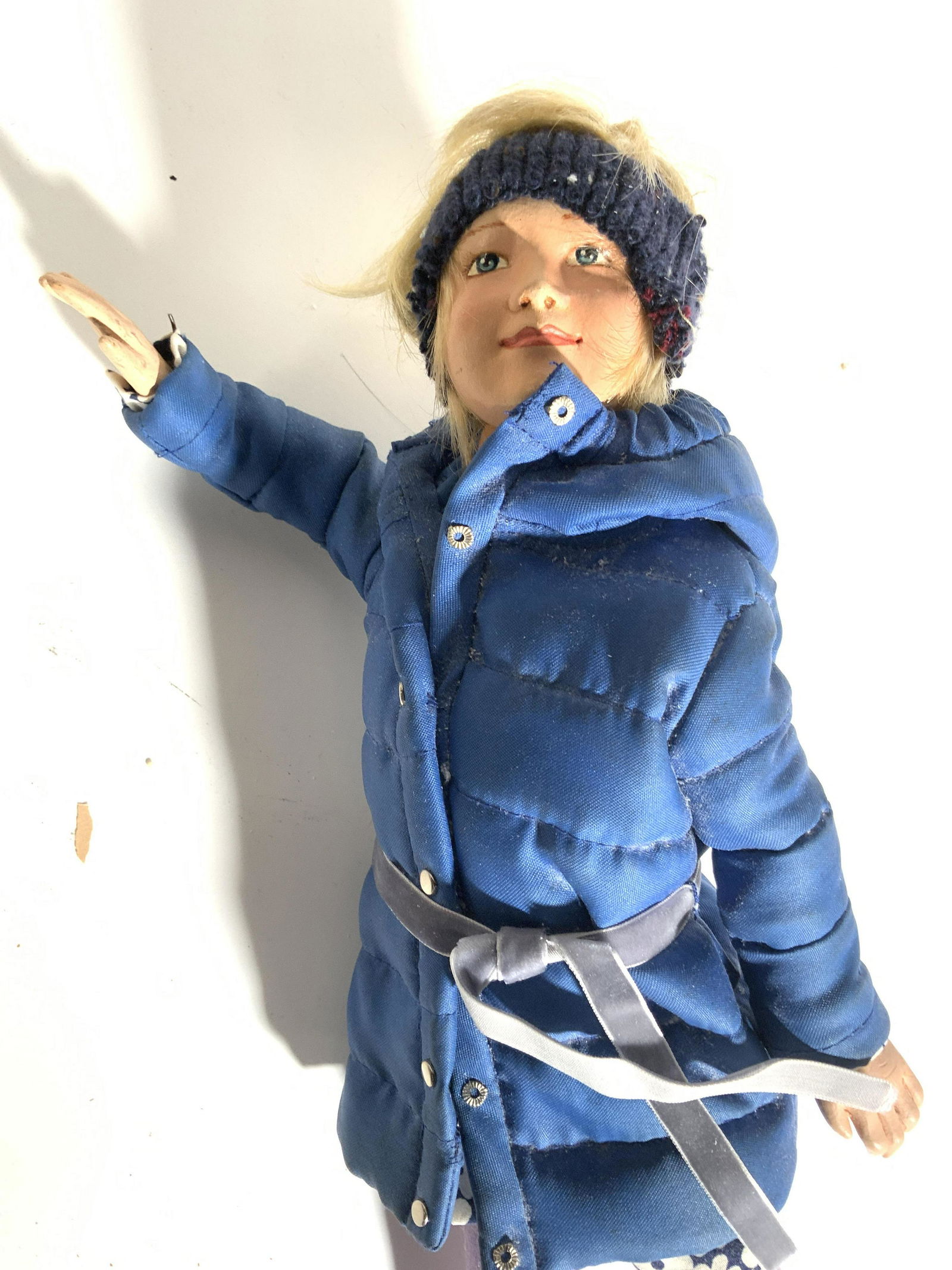 LORD & TAYLOR Window Display Puppet: This female puppet appears to be crafted from composite material and has custom made clothing. She is wearing a blue coat with floral shirt underneath, gold toned sneakers & mauve pants. Piece measure