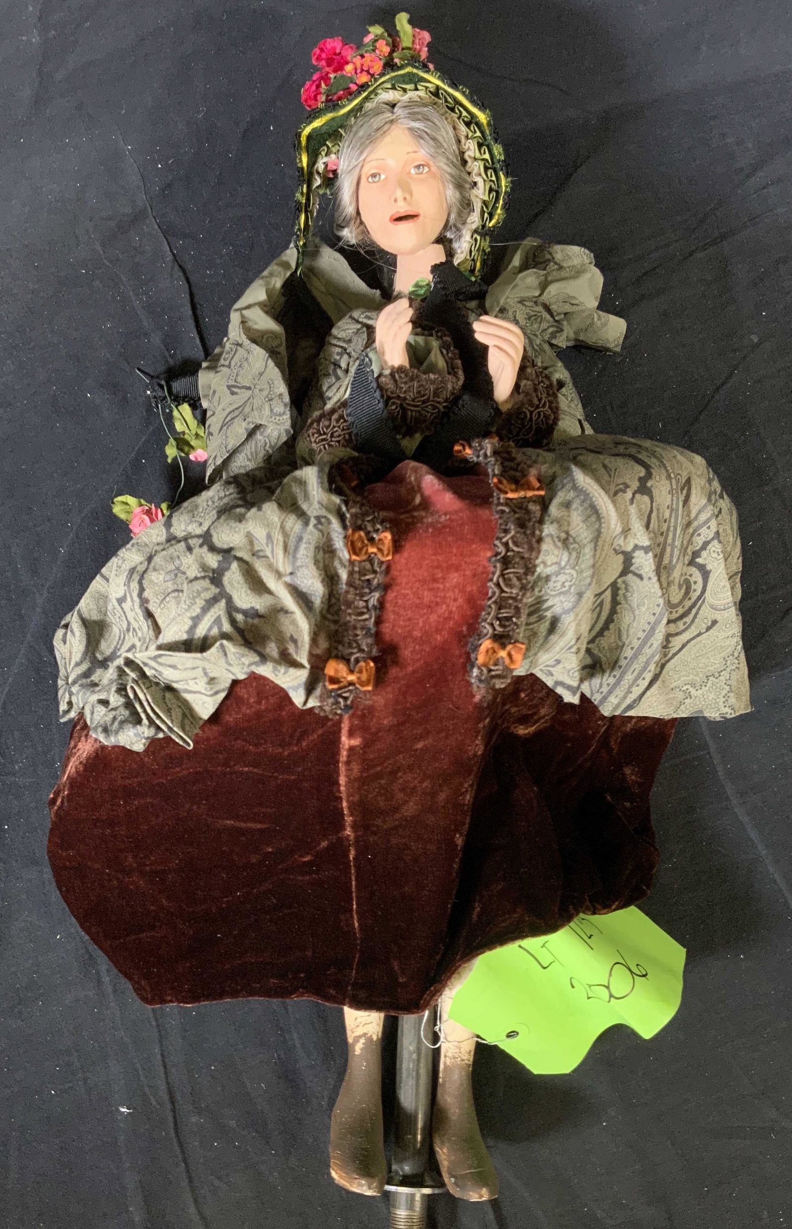 LORD & TAYLOR Elderly Woman Window Display Puppet: LORD & TAYLOR Elderly Woman Window Display Puppet, label reads ‘LT 12-3 2006’, a woman in a large period dress with flowered hat, measures 22 1/4 inches tall x 11 inches at widest point, head need