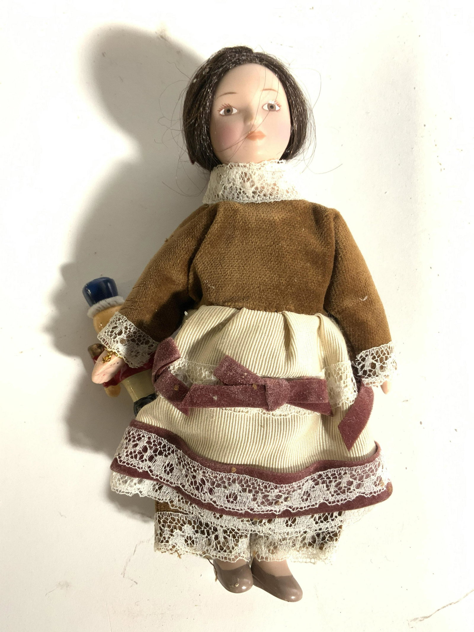 LORD & TAYLOR Window Display Puppet: This female puppet appears to be crafted from composite material and has custom made clothing. She is wearing a multi toned dress with doily crochet ends. Piece measures approx 6 inches tall 4 inches 