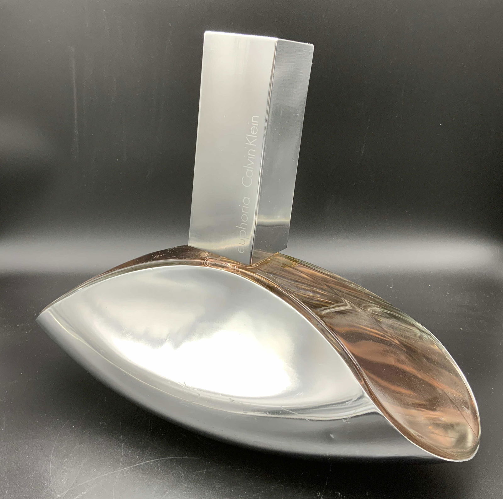 CALVIN KLEIN Euphoria Salesman’s Sample Bottle: CALVIN KLEIN Euphoria Salesman’s Sample Perfume Bottle, inscription to oversized bottle reads ‘Euphoria Calvin Klein’’, measures 8 3/4 inches tall x 10 3/4 inches at widest point, some surface