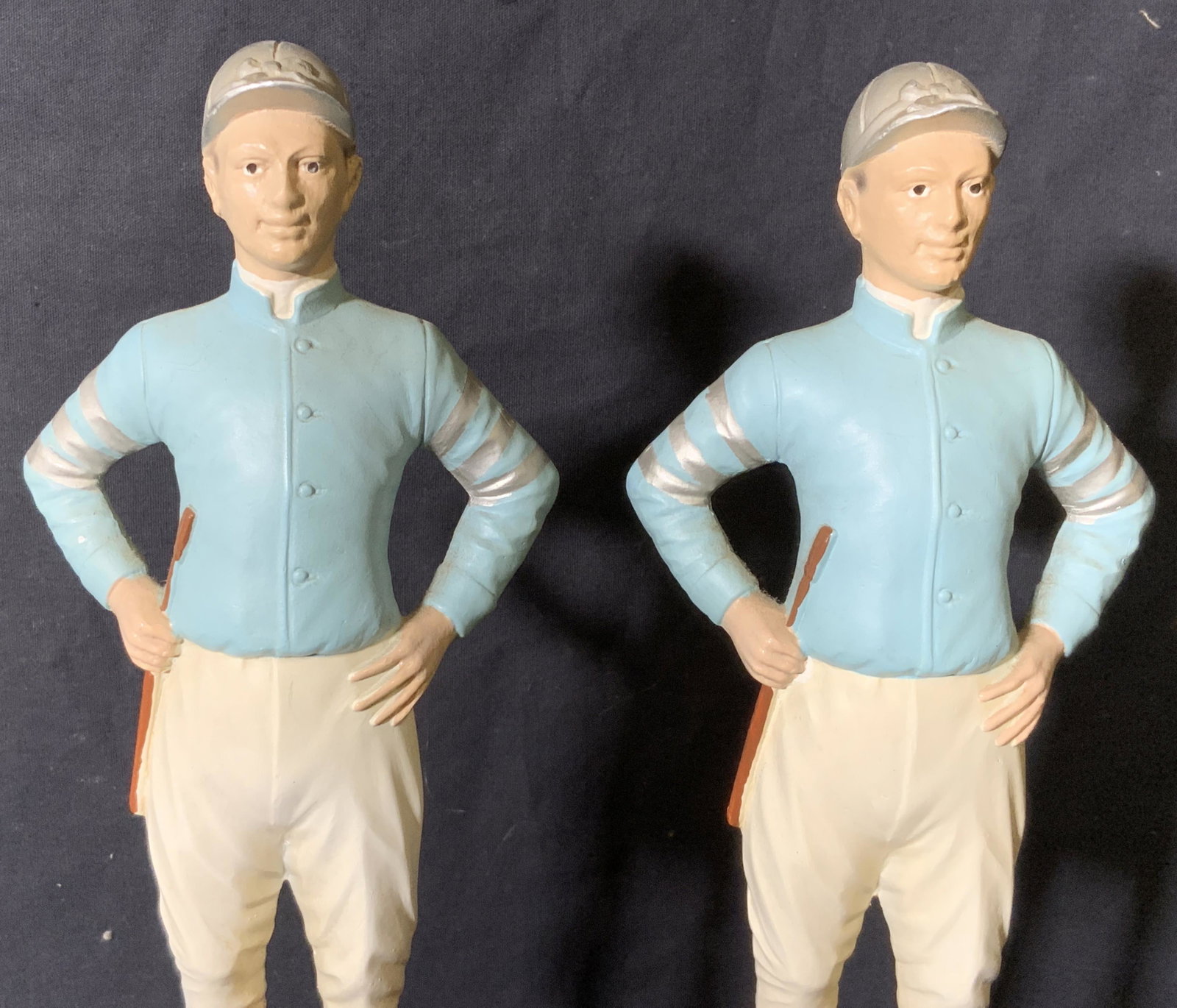 Pair Horse Jockey Statues: Pair Horse Jockey Statues, no apparent inscriptions or markings, both pieces and nearly identical, subject a man in a blue shirt and white pants with jockey shoes hat and crop whip, both statues are o