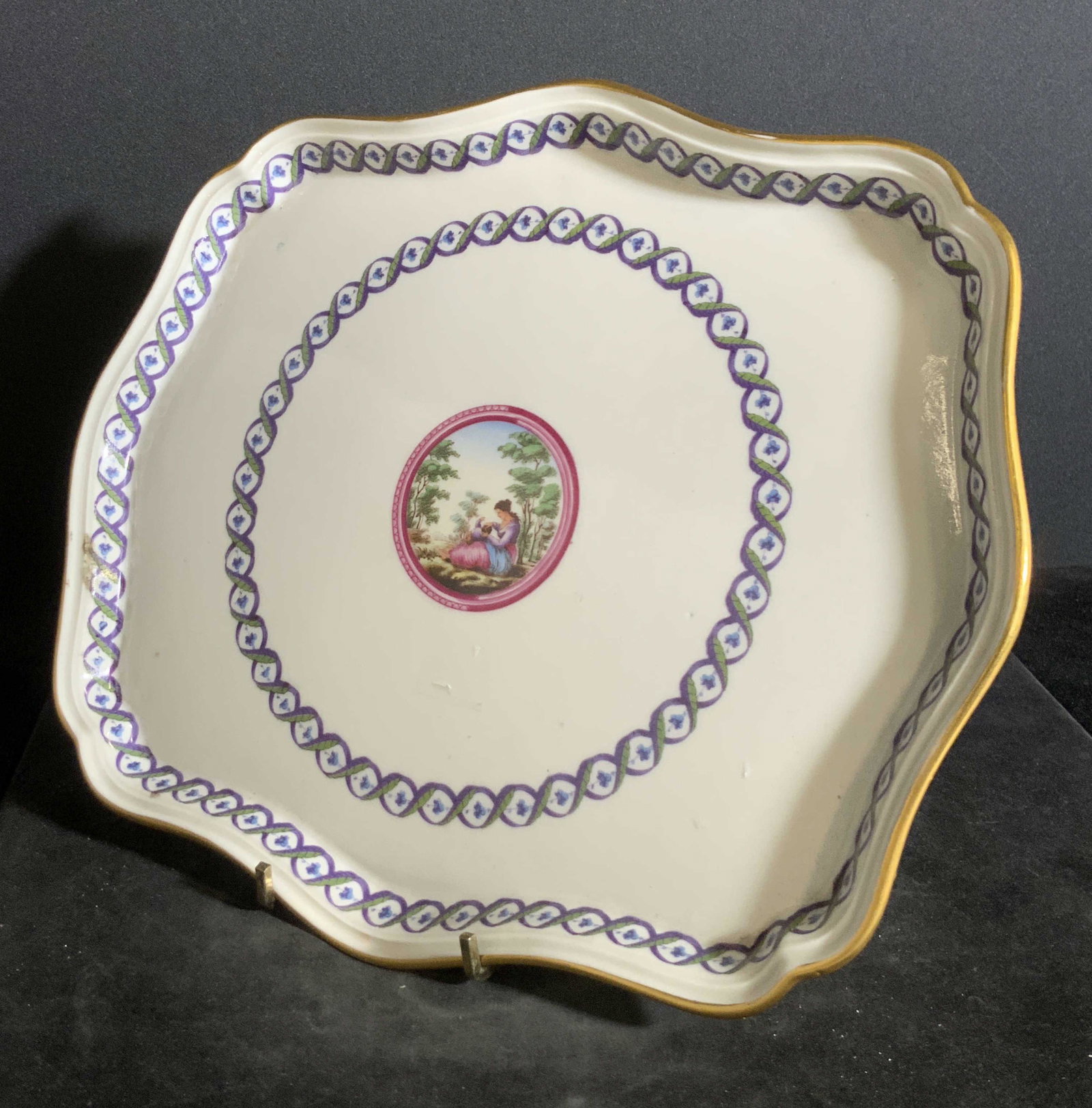 RICHARD GINORI Signed Italian Porcelain Plate: A white porcelain plate with repeating border patterns and a center design depicting a mother with her child. The rim is lined with gilt. The underside is signed RICHARD GINORI, MADE IN ITALY. Approx,