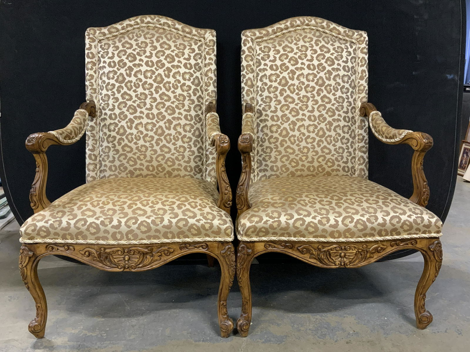 Pair Leopard Print Bergère Chairs: Pair of leopard print bergeres, wood frame is decorated with carved detailing, upholstery is single welt, decorated with a beaded fabric trim, all legs are cabriole styled. Each measures approx 46.5 i
