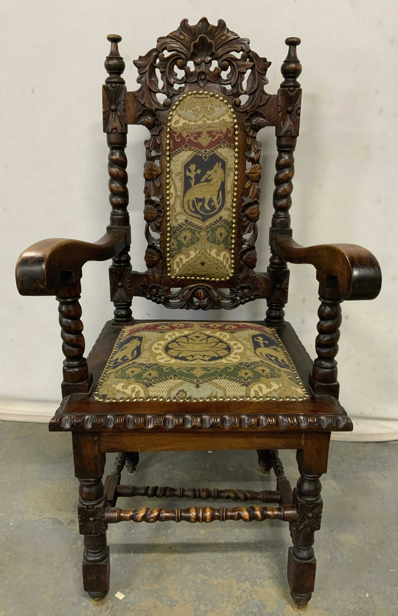 Vintage Gothic Style Mahogany Arm Chair: Vintage, possibly antique, gothic style armchair. Wood frame decorated with intricately carved detailing, stretchers, arms, and back decorated with barley twists. Seat and back are cushioned, upholste