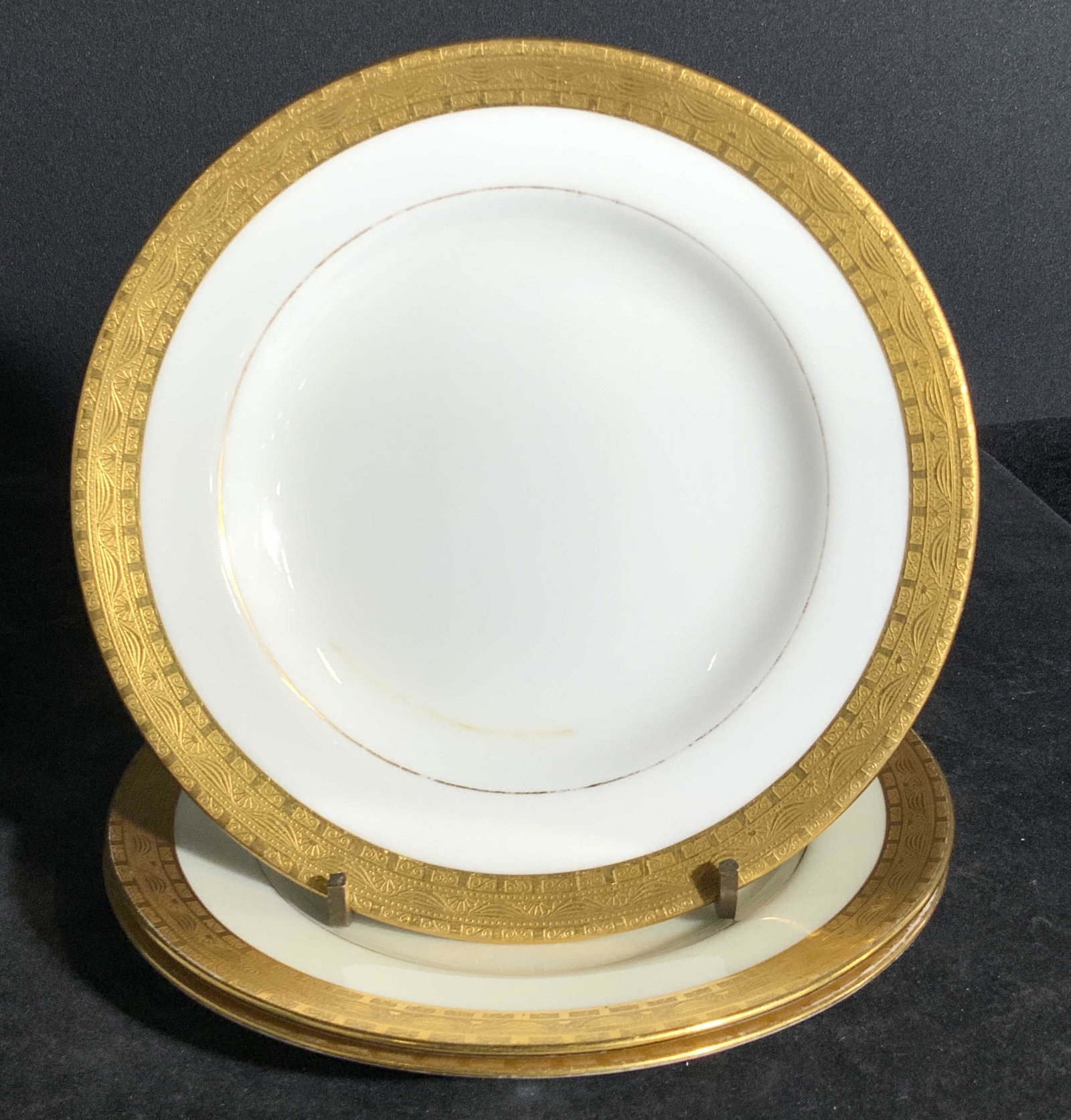 Set 3 CALDWELL & CO. English Porcelain Plates: Three white porcelain plates with gilt accents. The gilt border around the rim is slightly raised. The underside is stamped MINTONS. CALDWELL & CO. PHILADELPHIA. MADE IN ENGLAND. Approx, 6 x 6 in. Som