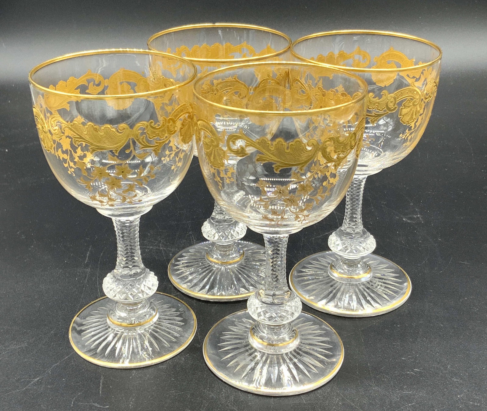 Set 4 Vntg Crystal & Gilt Wine Glasses, Stemware: Four colorless crystal cordial glasses with gilt accents. The gilt accents depict nature motifs, such as vines and florals, and are slightly raised. Cut crystal accents along the stem and base as well