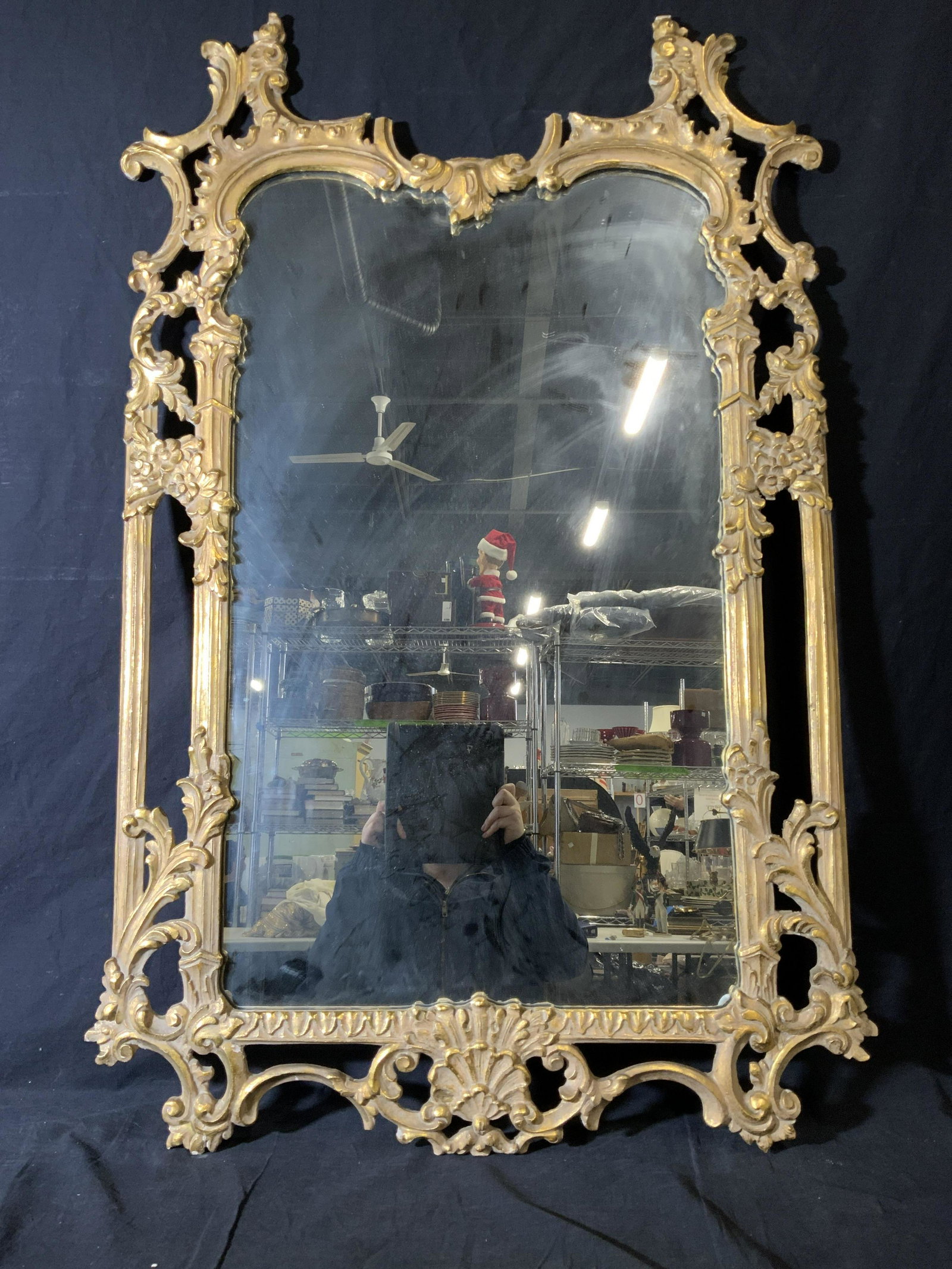 Hand Carved Ornate Gilt Wood Mirror: Hand carved ornate gilt wood mirror, frame to mirror grande ornate gilt wood with vine and floral designs, breaks and evidence of repair to one end, hanging wire to piece located to center of reverse,