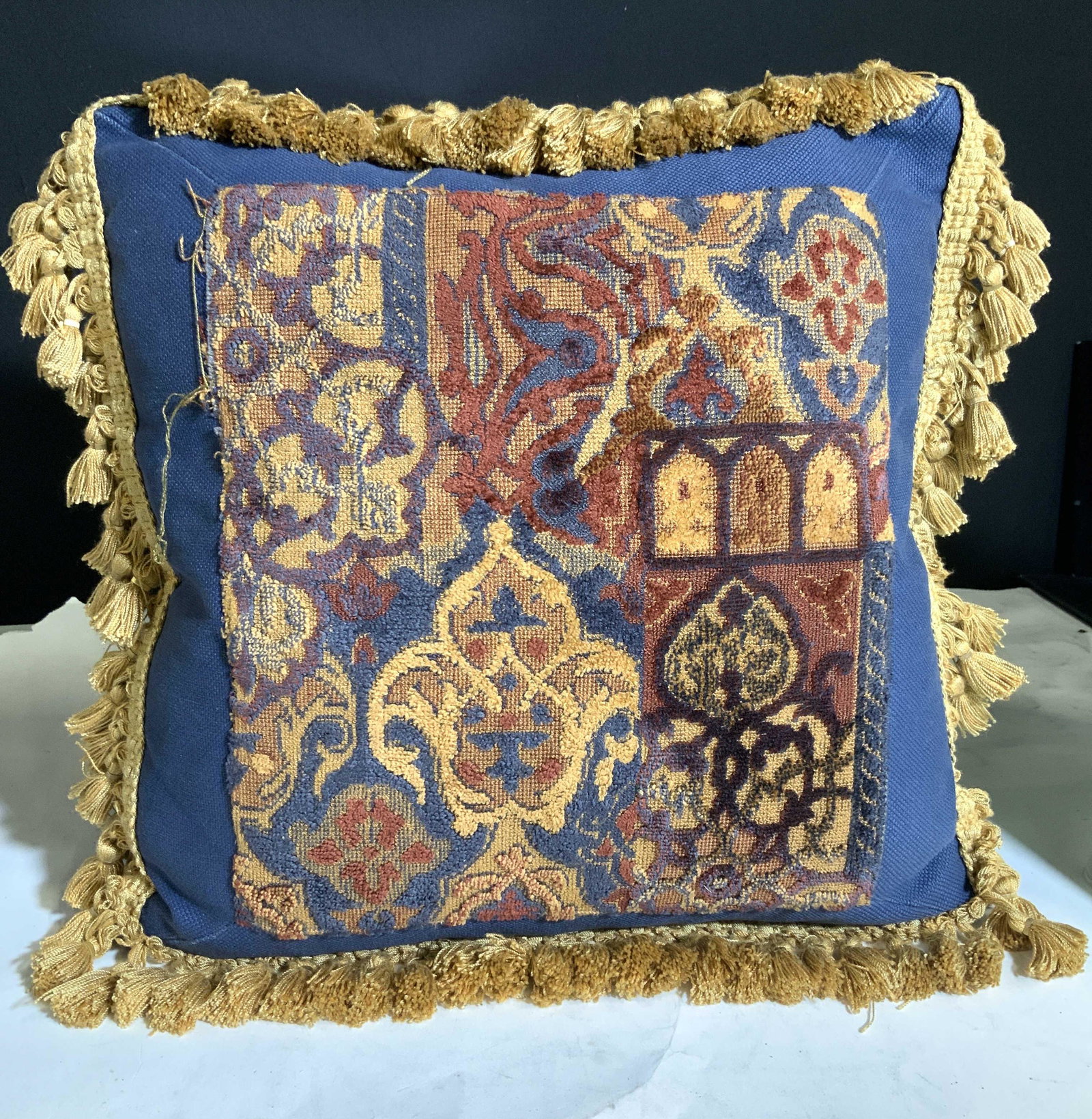 Tassel Border Feather Down Toss Pillow: Blue cotton canvas with Middle Eastern/ Indian Velour center design, full of rich orange and reds. Gold tassel thread piping . Pillow form is sewn in , feather and / or down. Some threads are loose, m