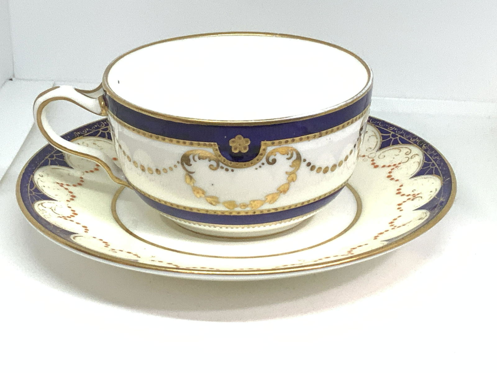 WEDGWOOD Porcelain Tea cup & Saucer, England: SIGNED tea for one set. 2 pcs of Fine English Porcelain, Hallmarked Wedgwood Made in England with additional piece numbers ‘x 7204’ on cup & ‘ W 2074 20’ on saucer. Cobalt blue with gilt in re