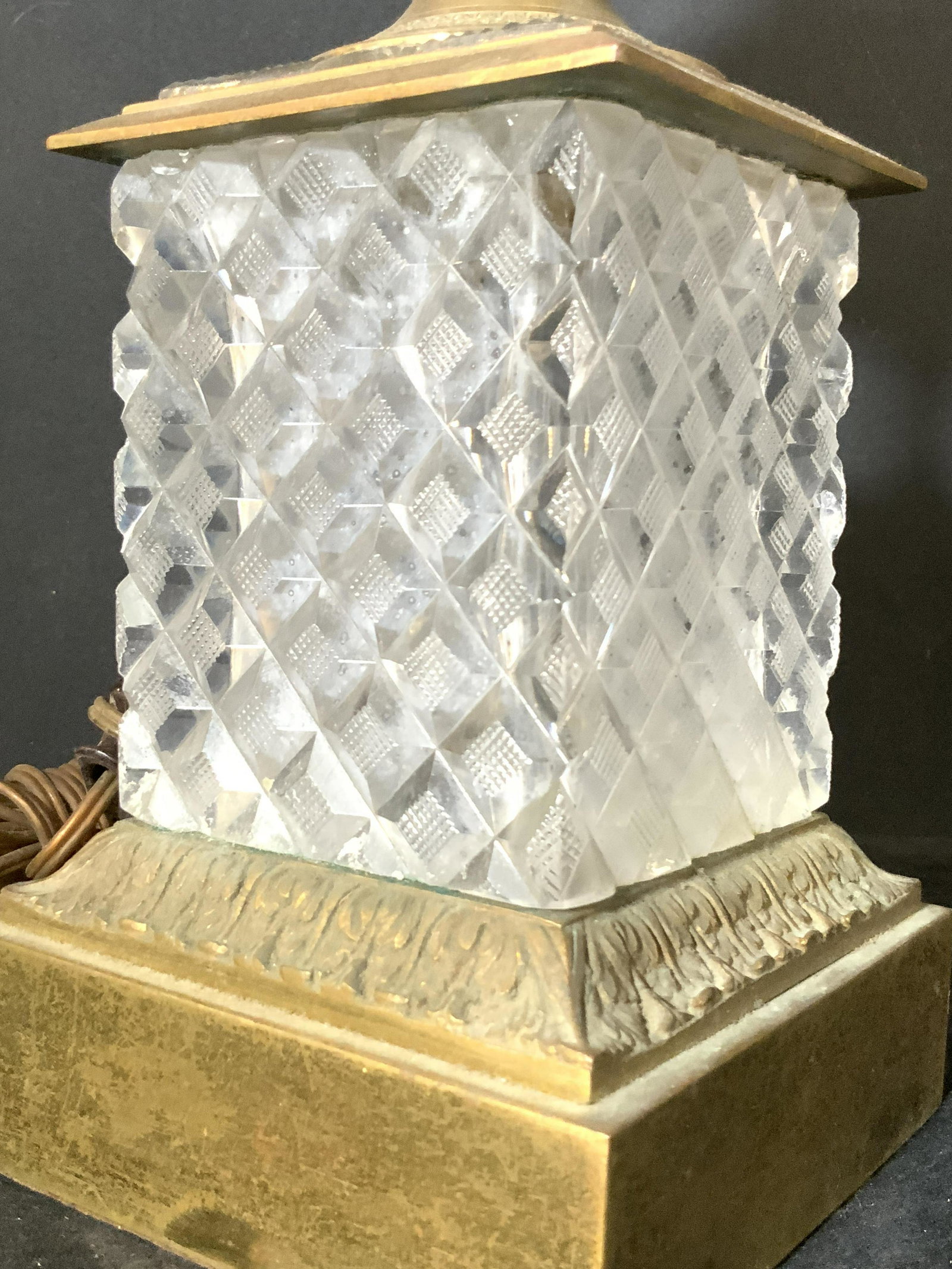 Cut Crystal & Brass Tabletop Lamp, Lighting: A tabletop lamp comprised of cut crystal and etched brass. Possibly vintage. The etched and embossed brass designs are throughout the entire piece. On each side of the cut crystal there are female fig