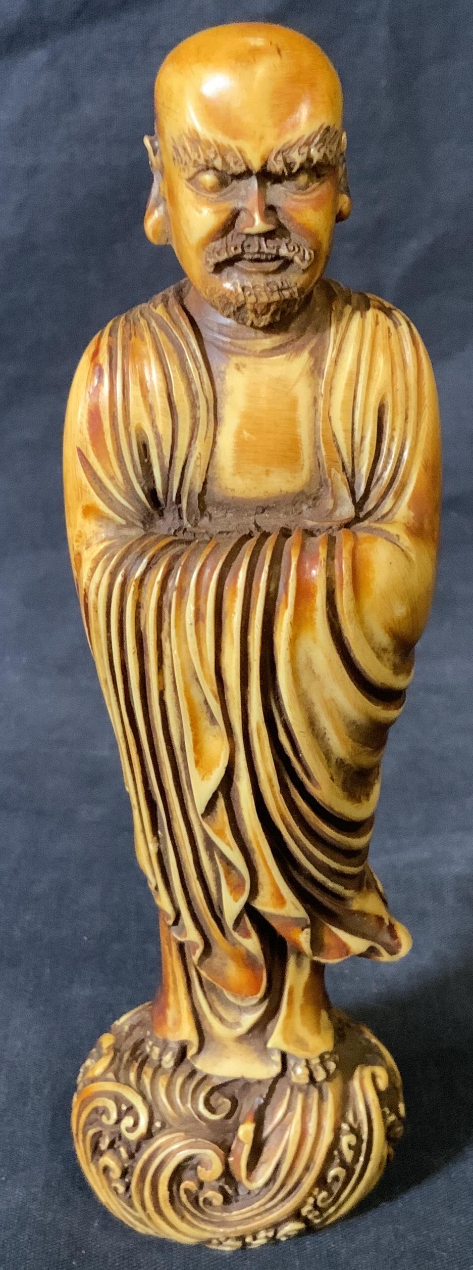Hand Carved Wooden Asian Sculpture: Hand carved wooden Asian sculpture, no apparent inscriptions or markings, subject a bald Asian man with flowing robes standing atop waves, piece measures 6.5 inches at tallest point, some wear to surf