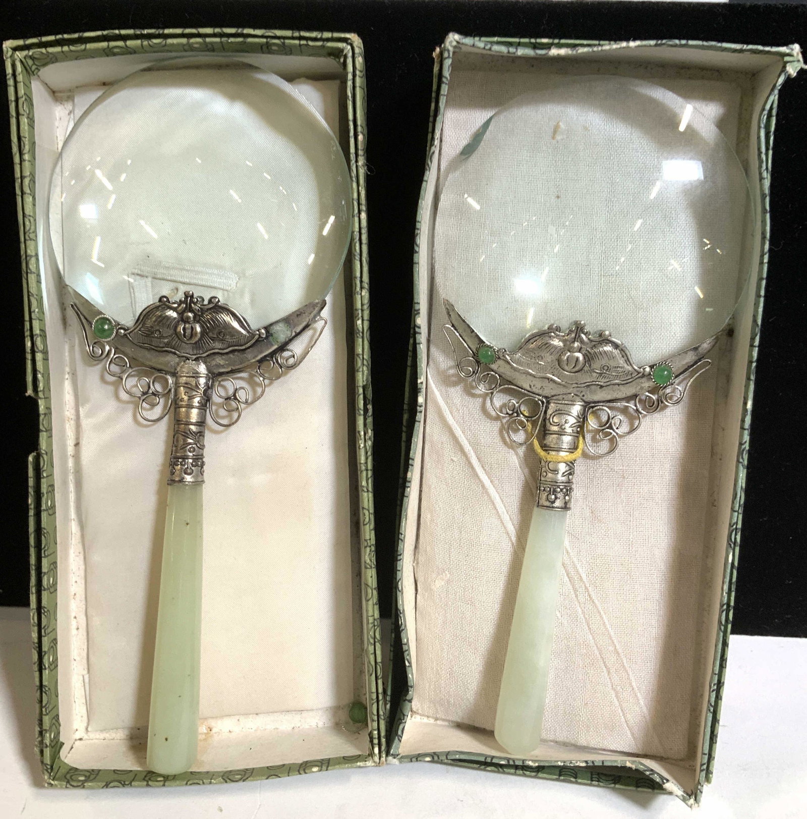 Pair Jade Handle Magnifying Glasses in Org Box: Two vintage magnifying glasses in original boxes. Handles are Solid piece of JADE. Orname metal decor connects jangle to glass. One has rim chip in glass, other needs glass gem glued. Org boxes are gr