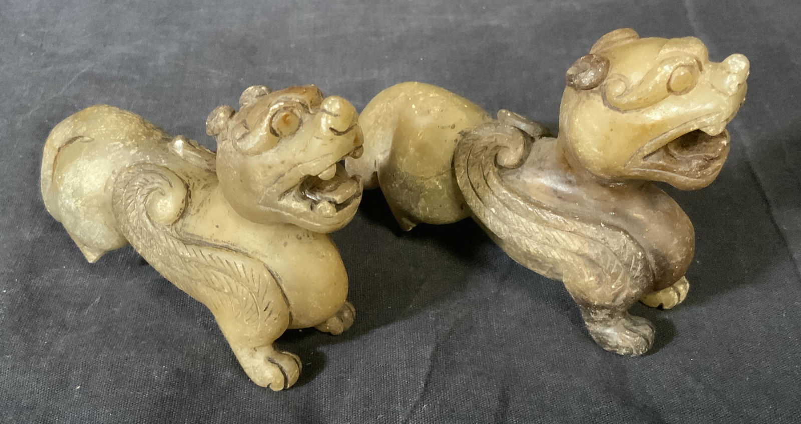 Pair Hand Carved Stone Fu Dogs: Pair hand carved stone fu dogs, no apparent inscriptions or markings, both are missing their back right foot, one is slightly large than the other otherwise are identical, larger of the two measures a